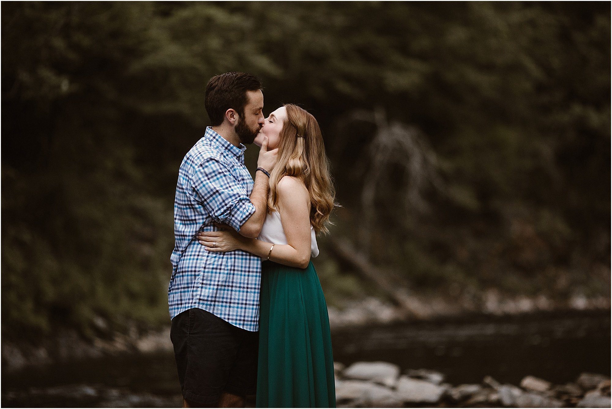 boy and girl kissing on riverbank