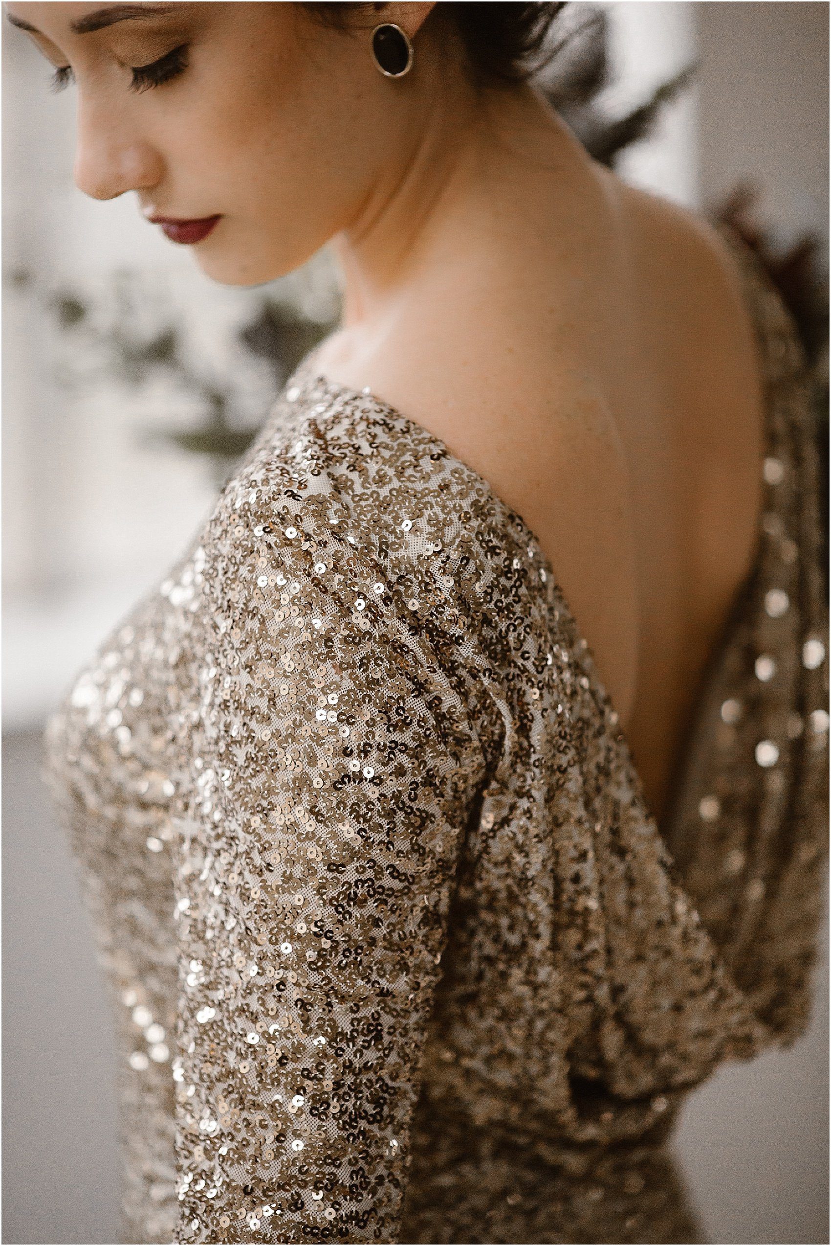 brides wears black earrings and chic makeup in gold sequin dress 