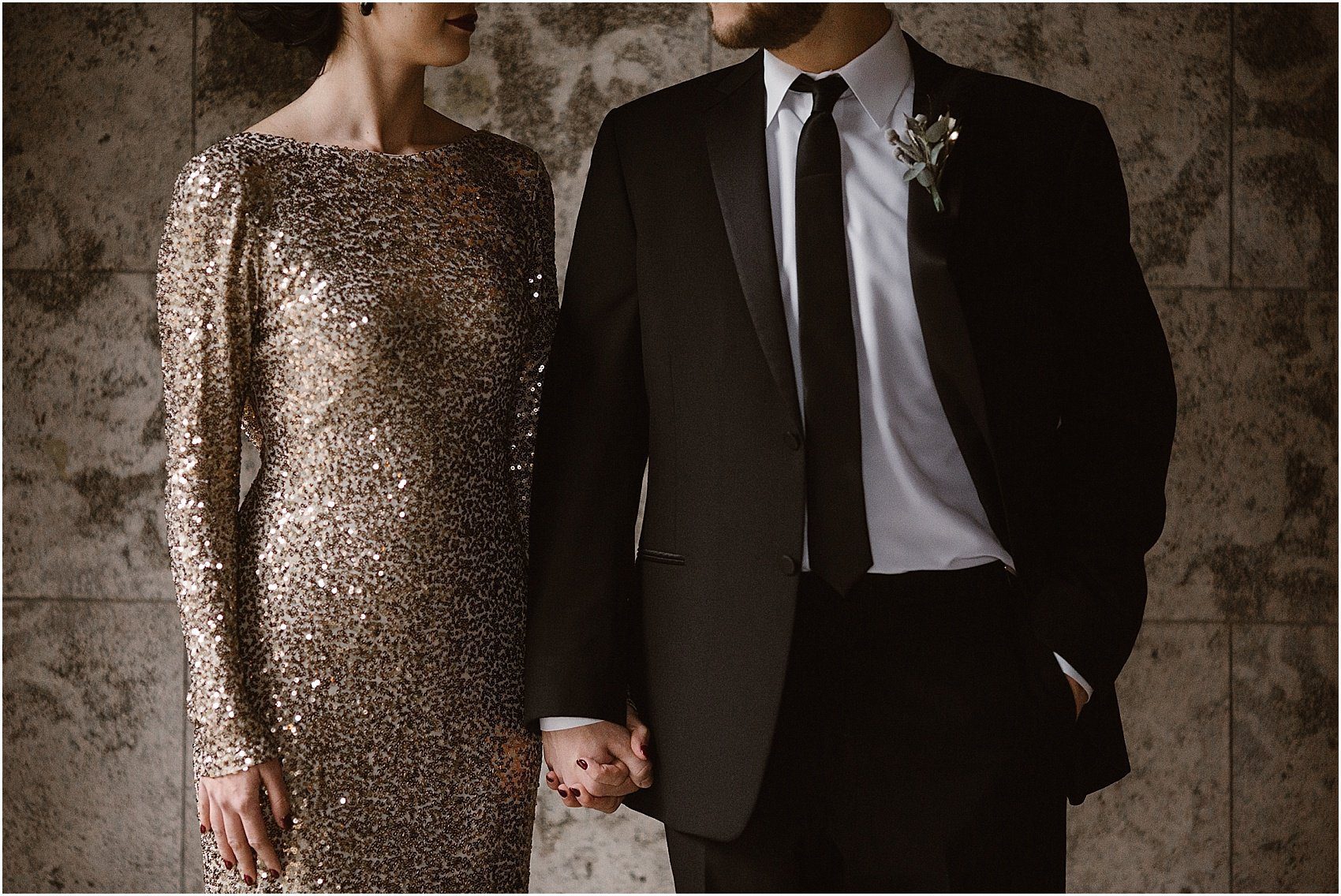 woman in gold dress holds hand with man in black suit at black and gold wedding
