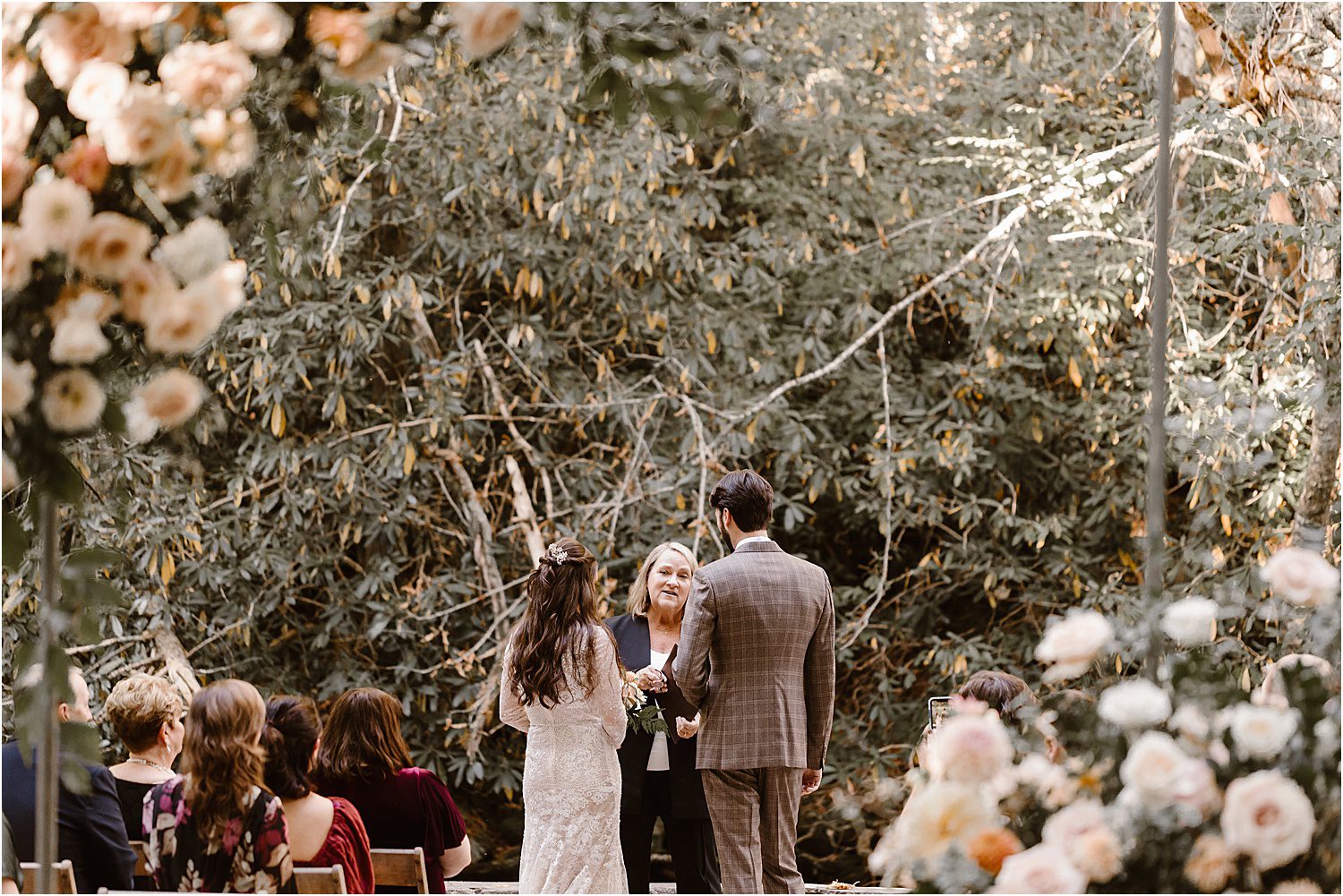 bride and groom enter ceremony and stand at officiant in the forest