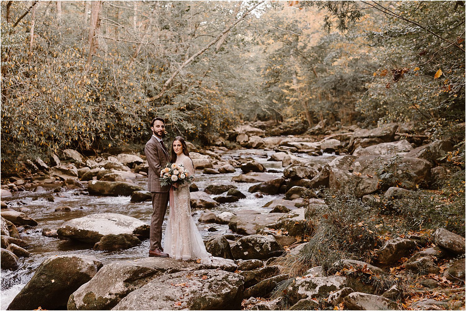river photos of bride and groom standing on rocks