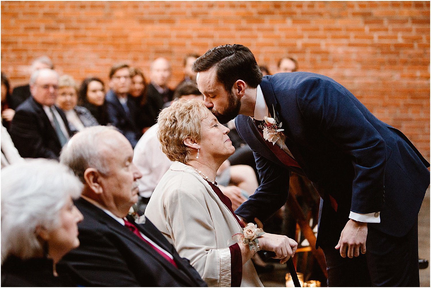Groom kissing mother on his wedding day