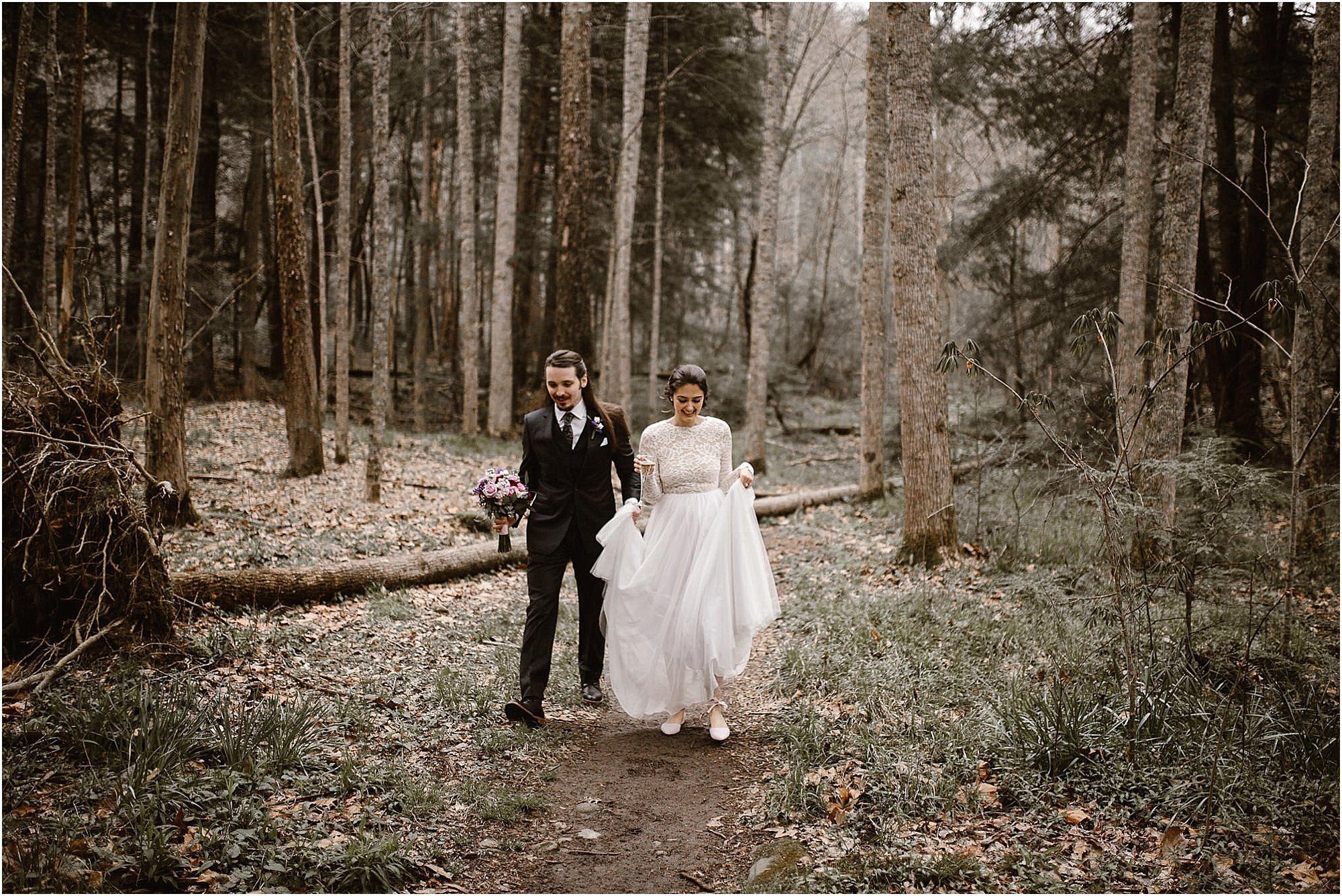 Bride and groom walking in woods at Elkmont