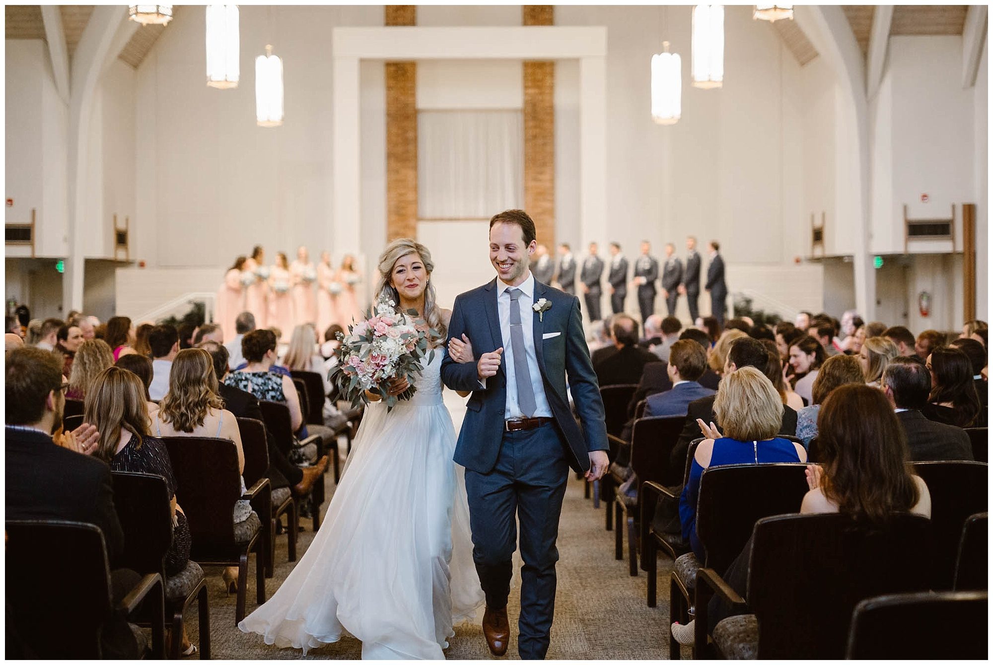 bride and groom walk down aisle at church