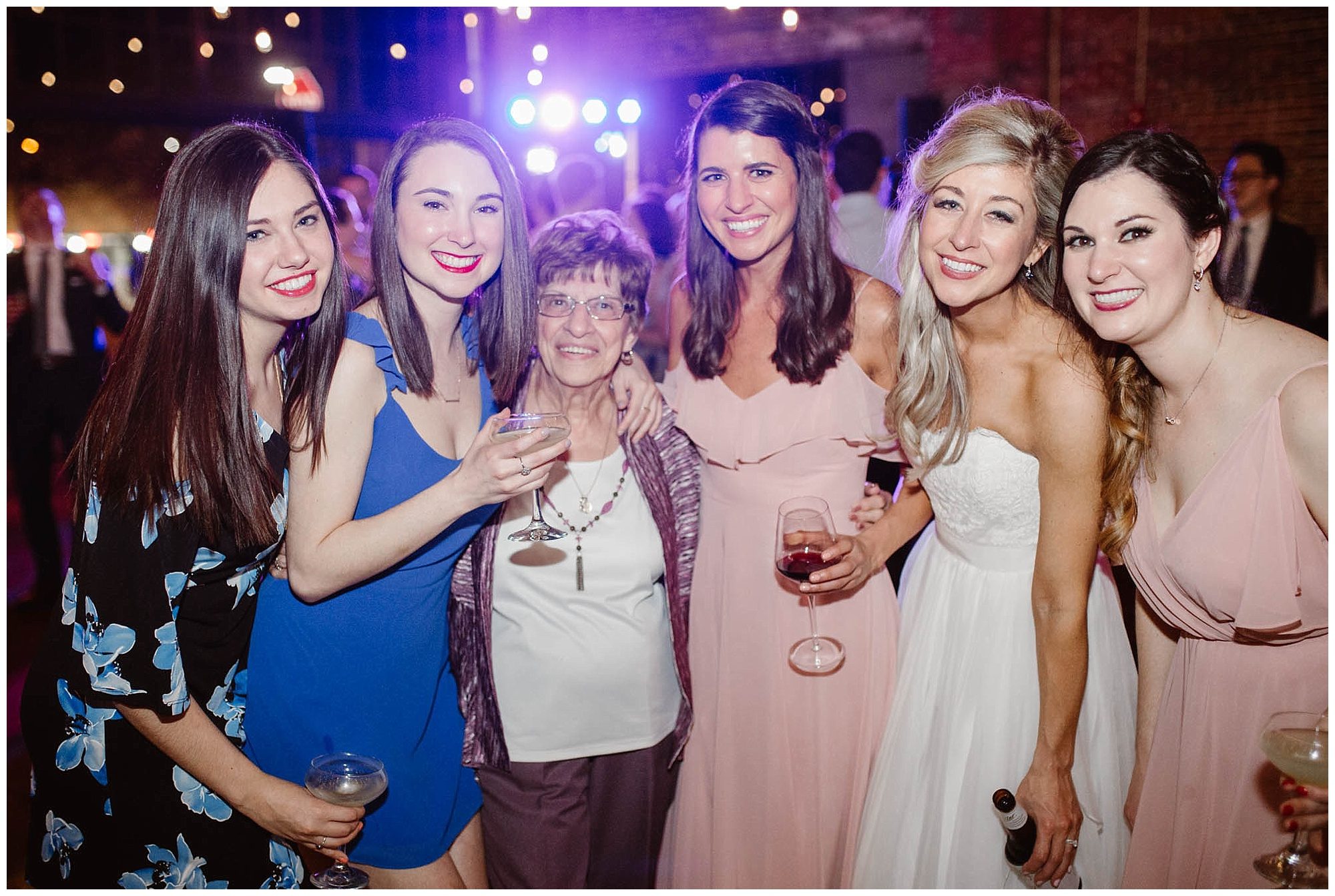 group photo of bride with bridesmaids, guests, and grandmother