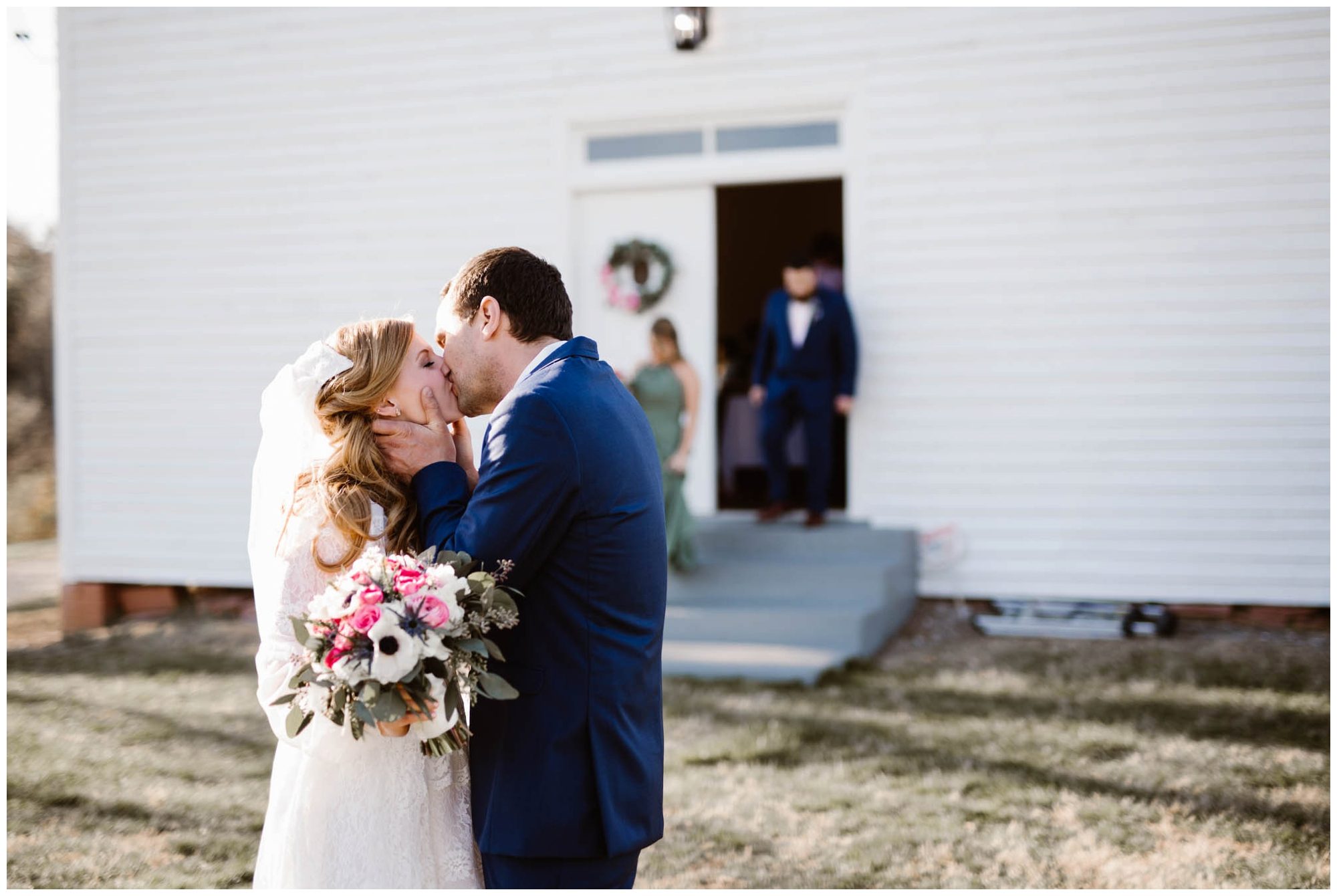 bride and groom kiss outside of church on wedding day
