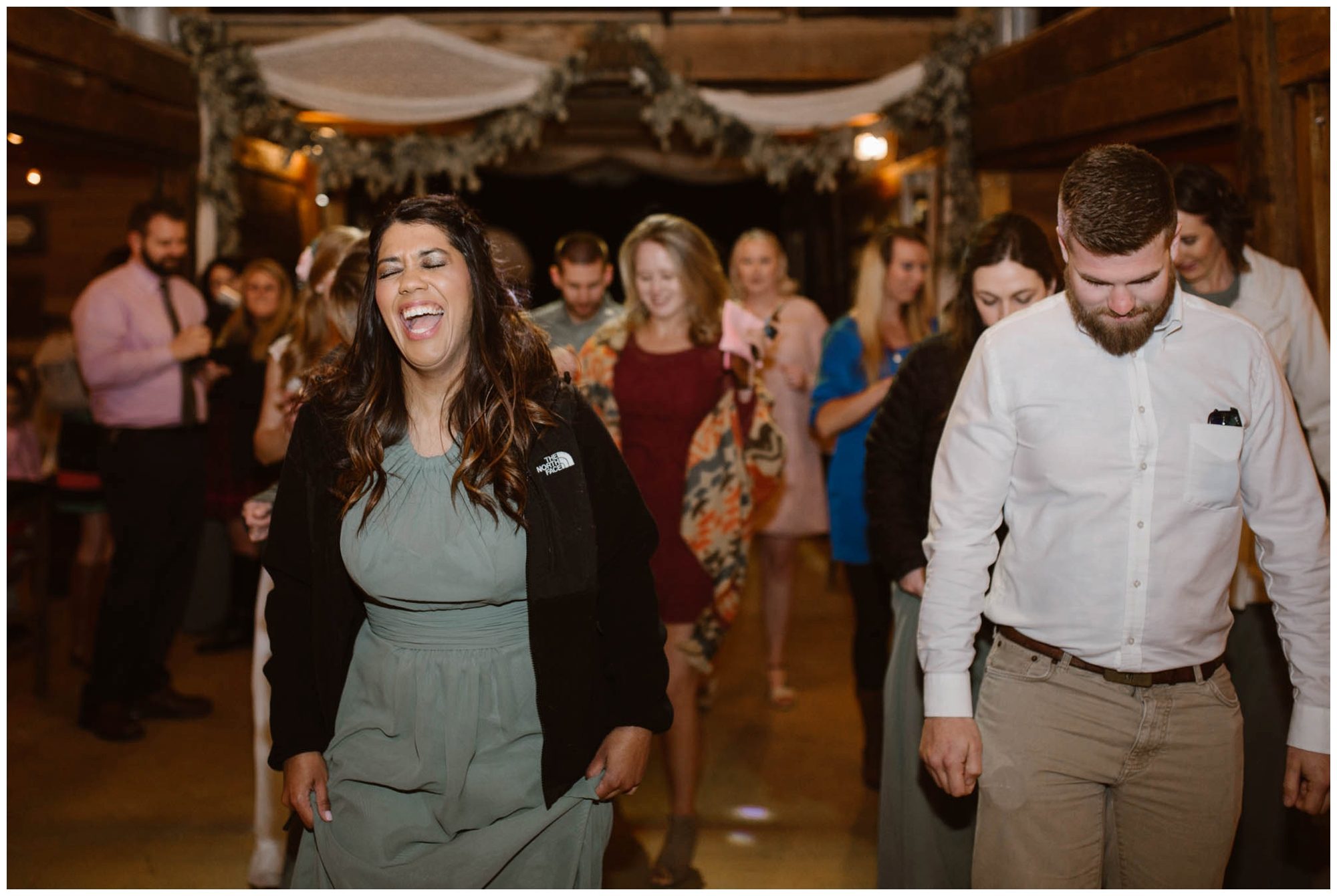guests dancing at wedding reception in barn