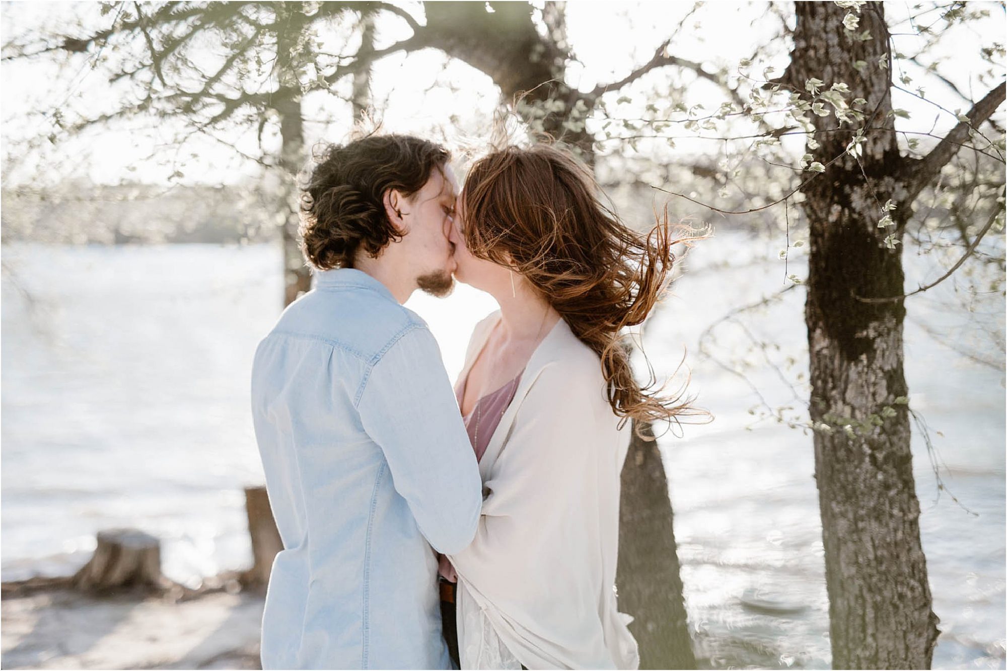 man and woman kissing with hair blowing in wind