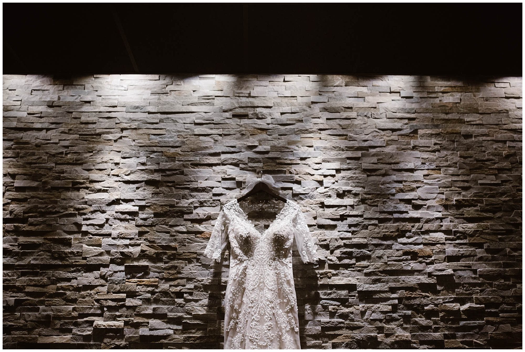 wedding dress hanging on brick wall