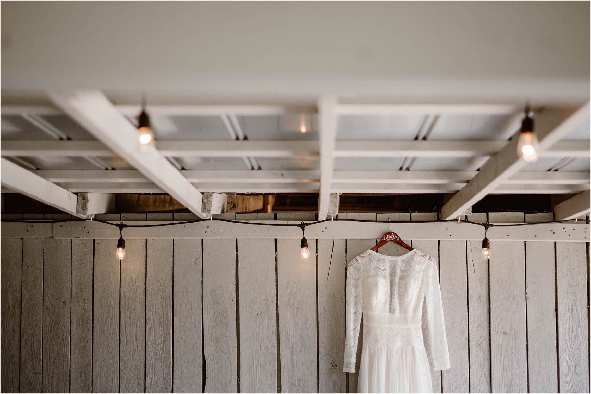 Wedding dress hanging on white rafters