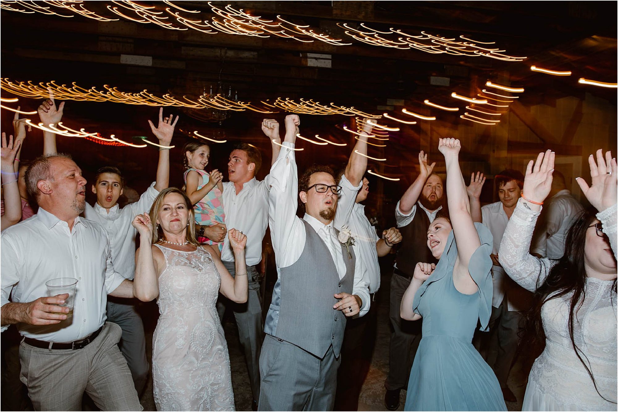 groom dancing with guests at wedding reception