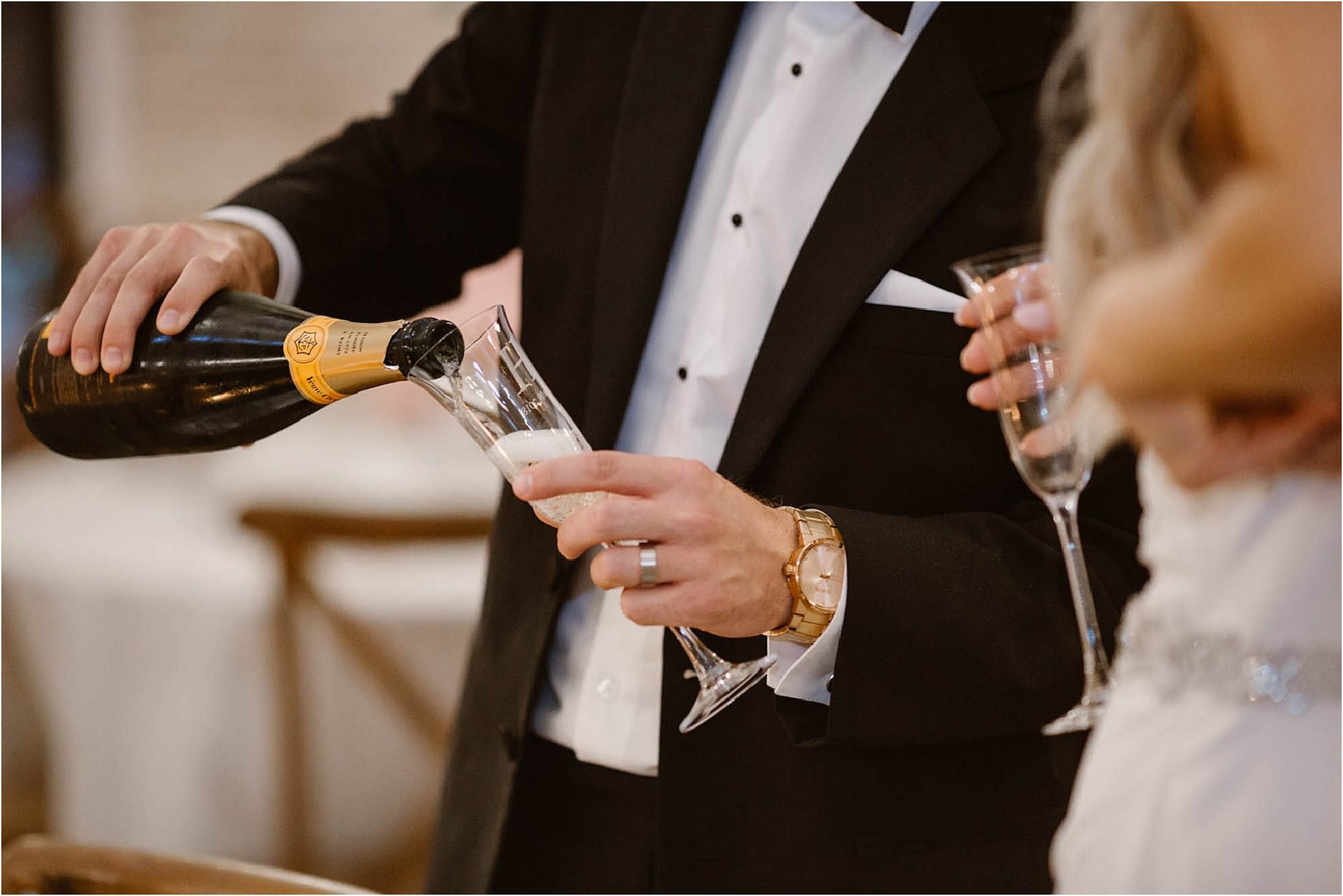 groom pouring champagne into glass