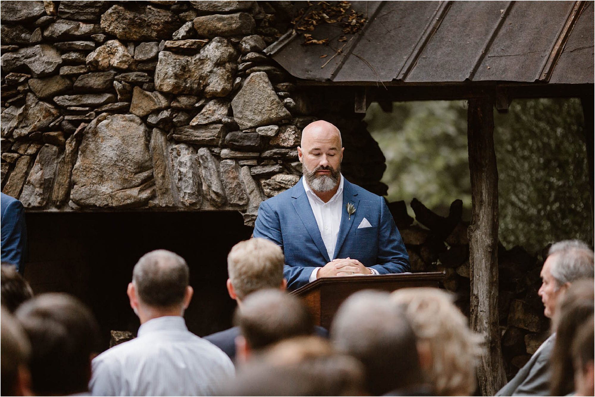 man in blue suit jacket reading at wedding ceremony