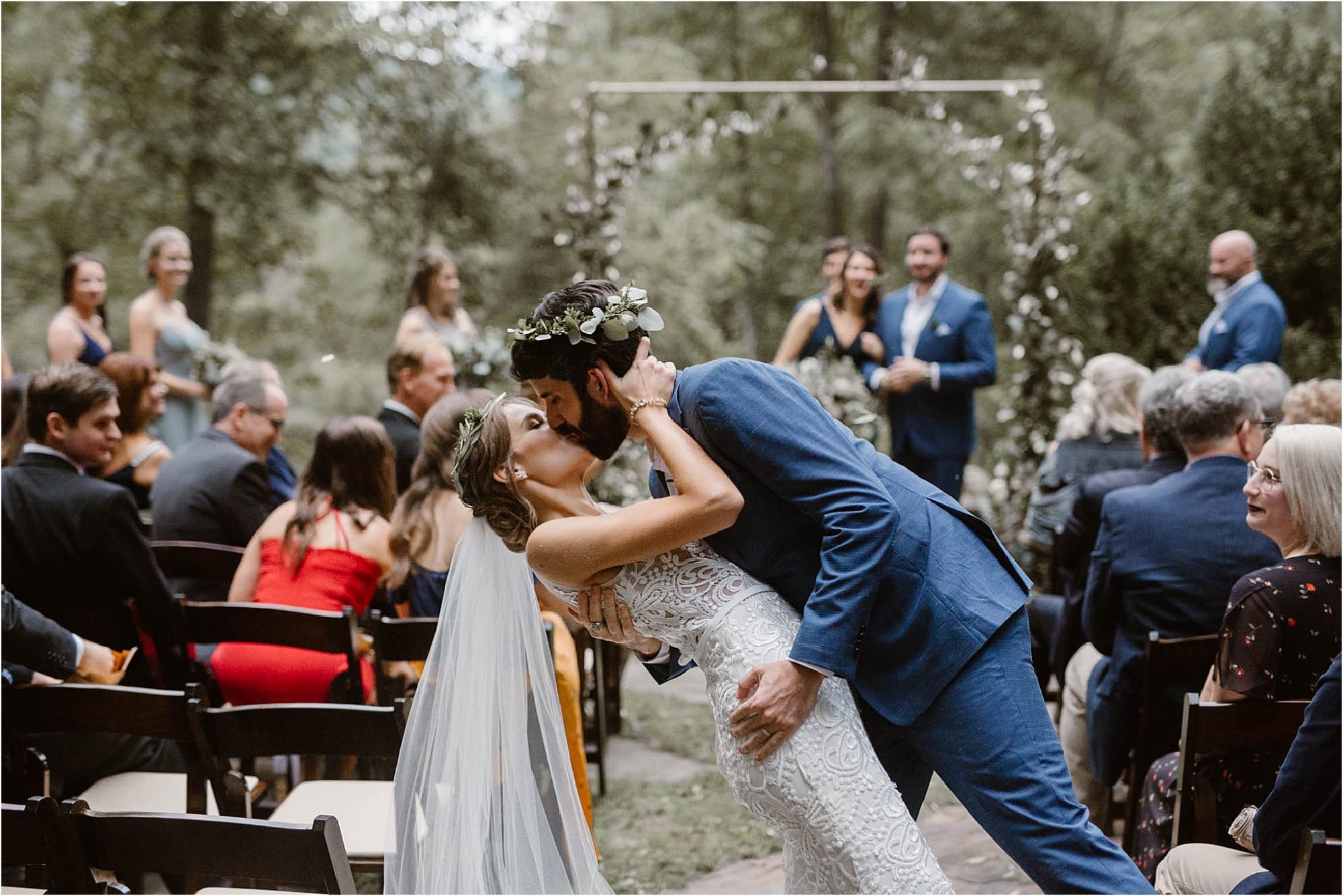 bride and groom kiss in aisle at wedding ceremony at North Carolina Vineyard