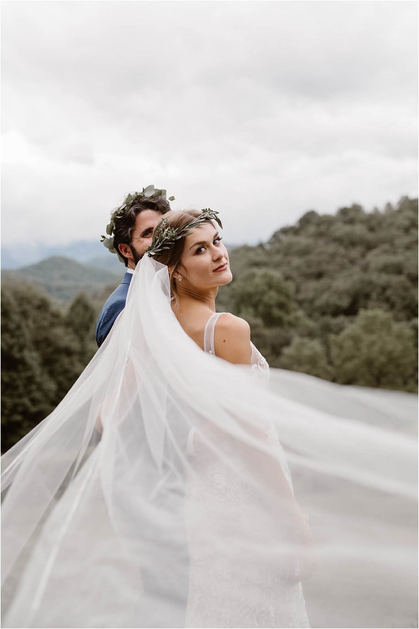 bride looking backwards over veil with greenery flower crown on her head