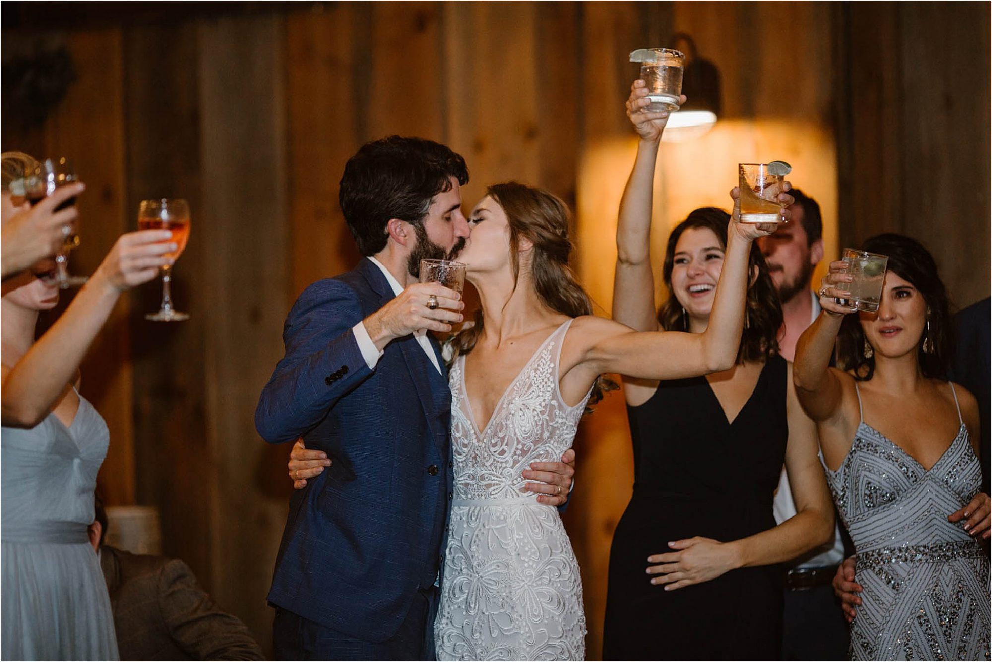 bride and groom kissing while toasting at wedding reception