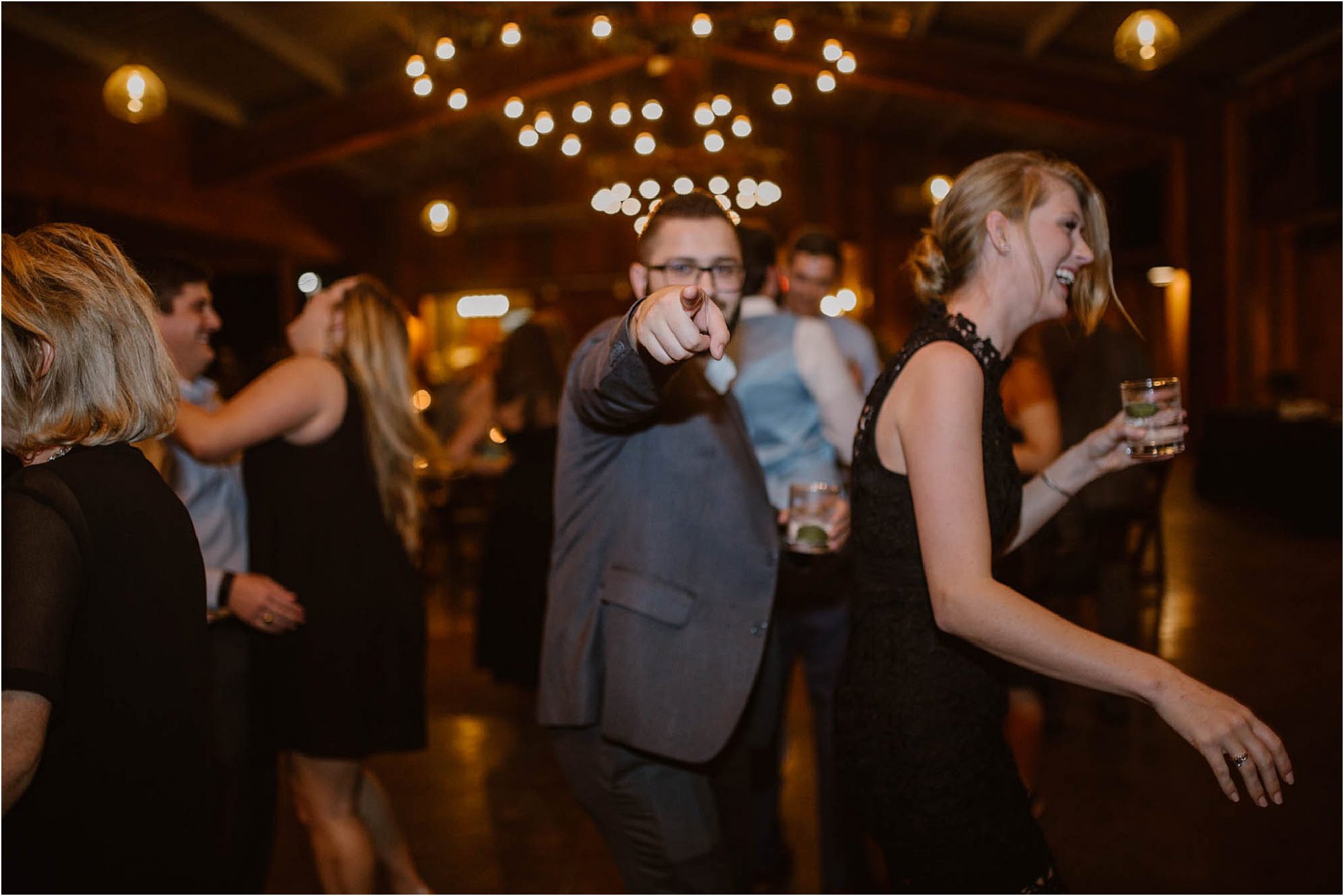 man pointing at camera at wedding reception