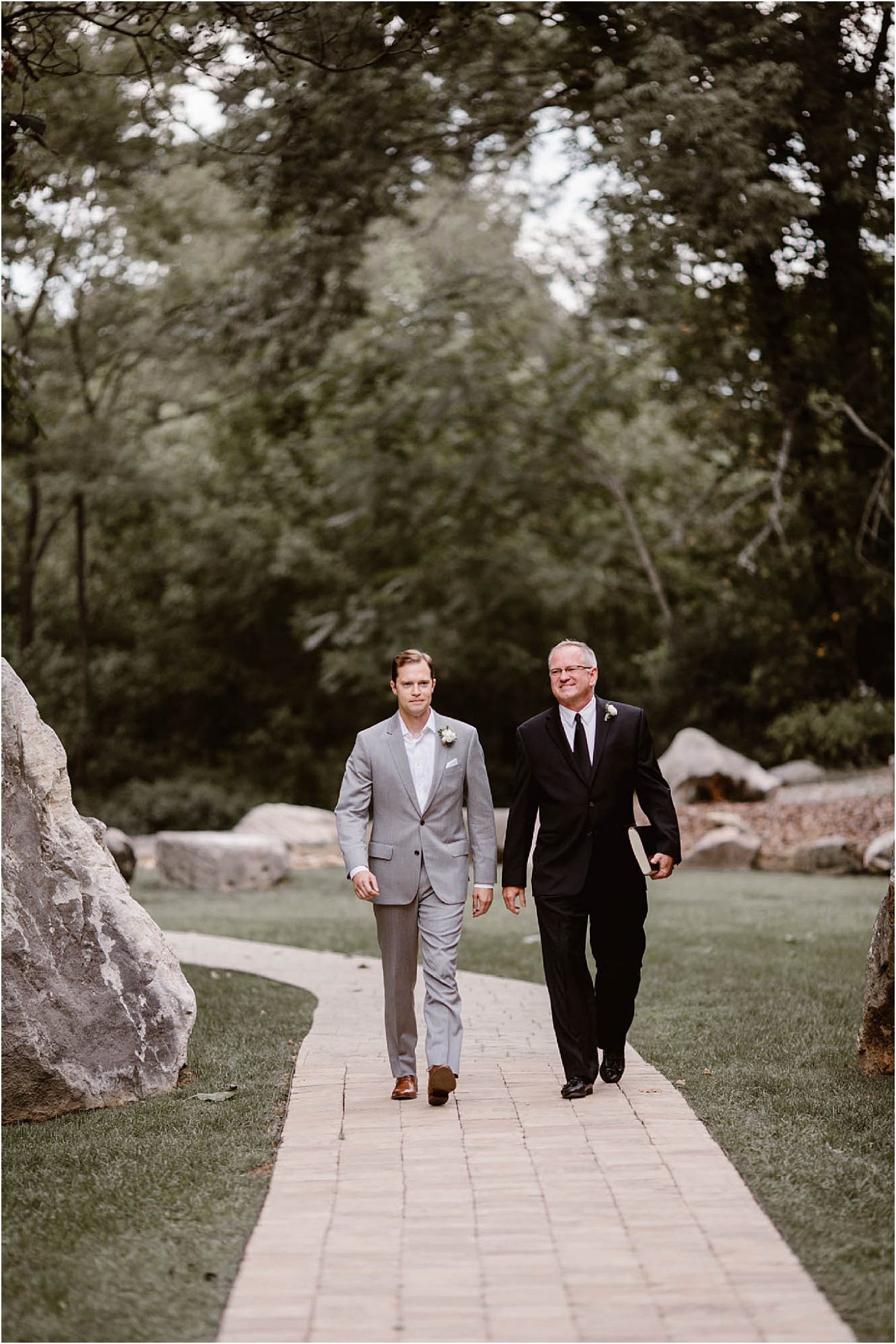 groom and officiant walking down pathway