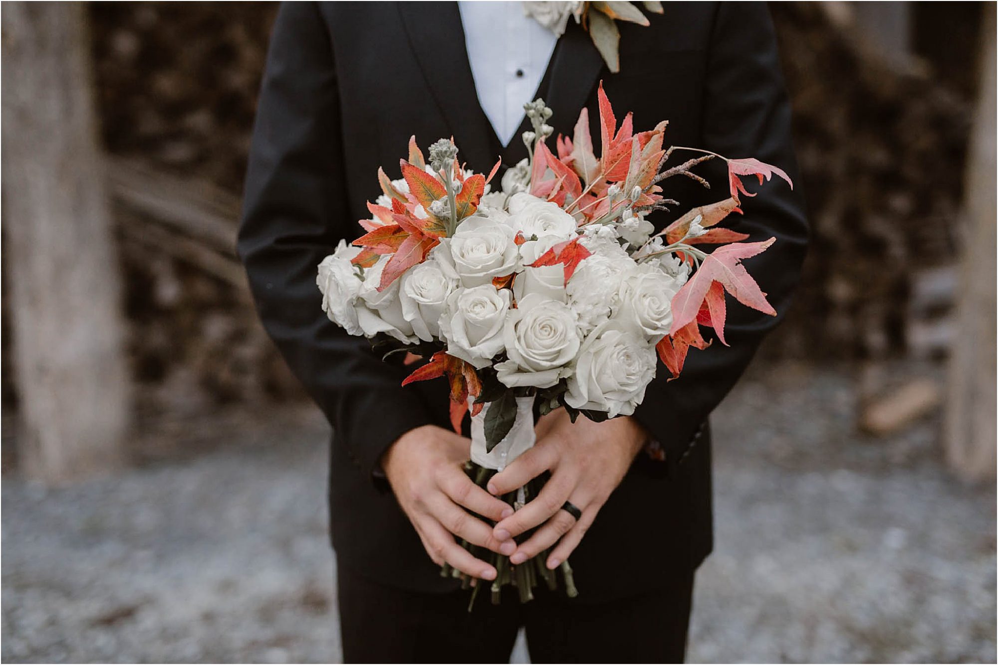 groom holding fall wedding bouquet