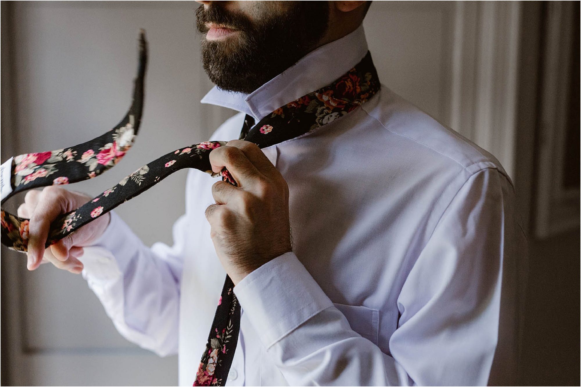 man putting on floral tie