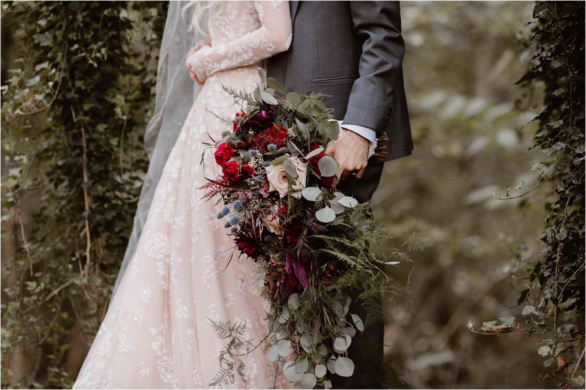 groom holding red and pink bouquet