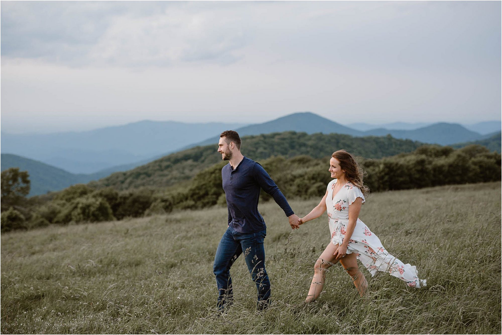 man and woman walking in field on mountain top