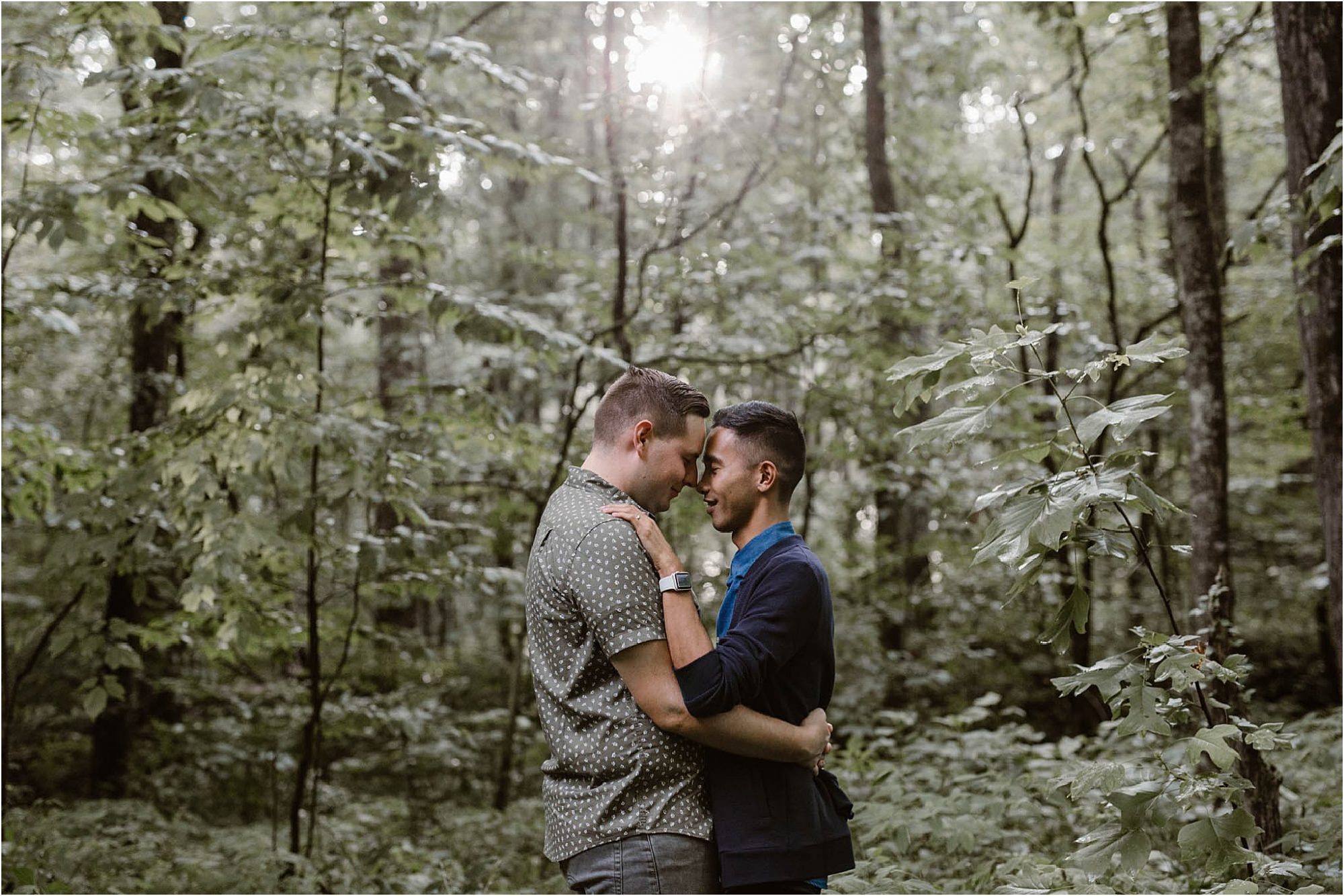two men kissing in forest