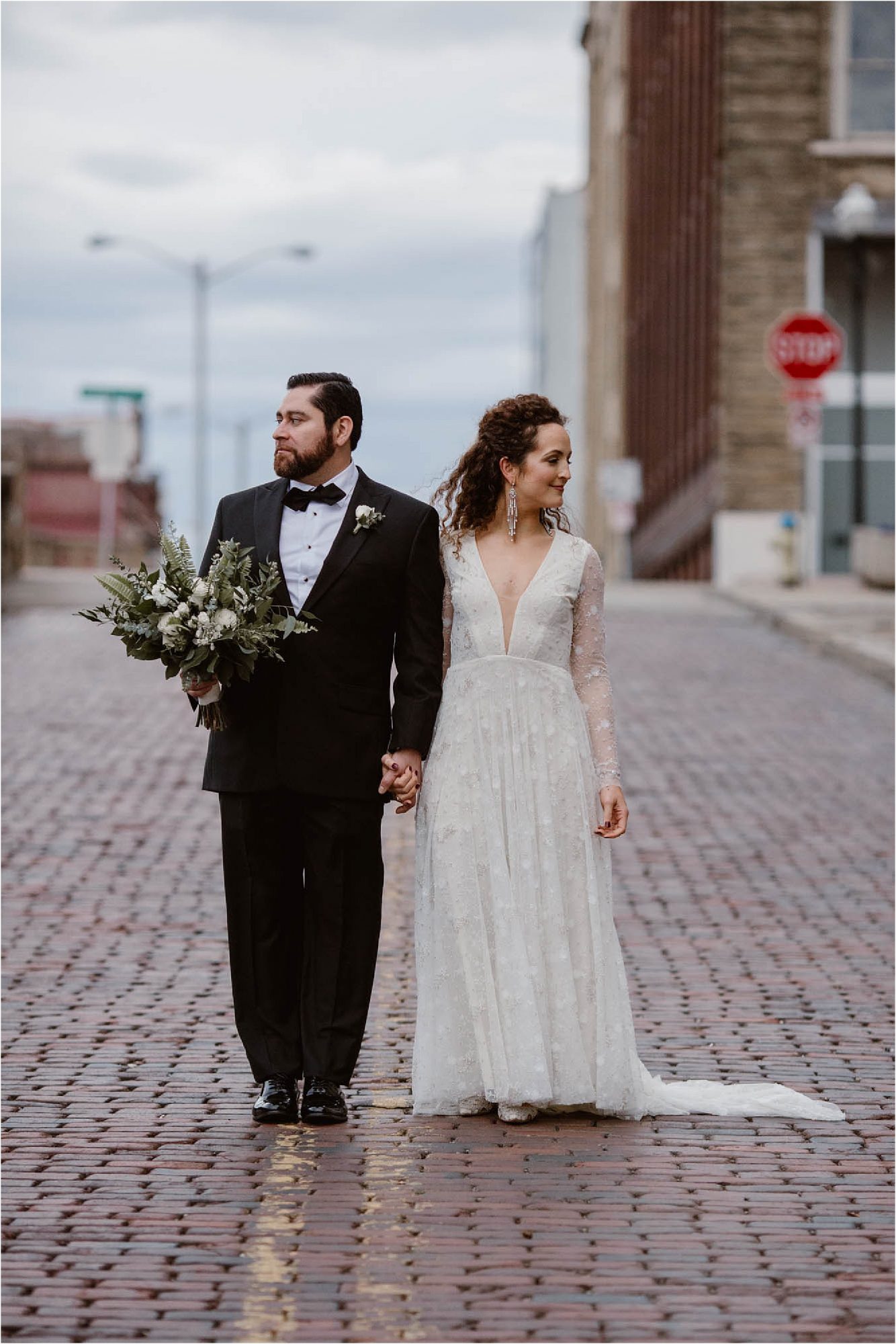 bride and groom standing next to each other looking opposite directions