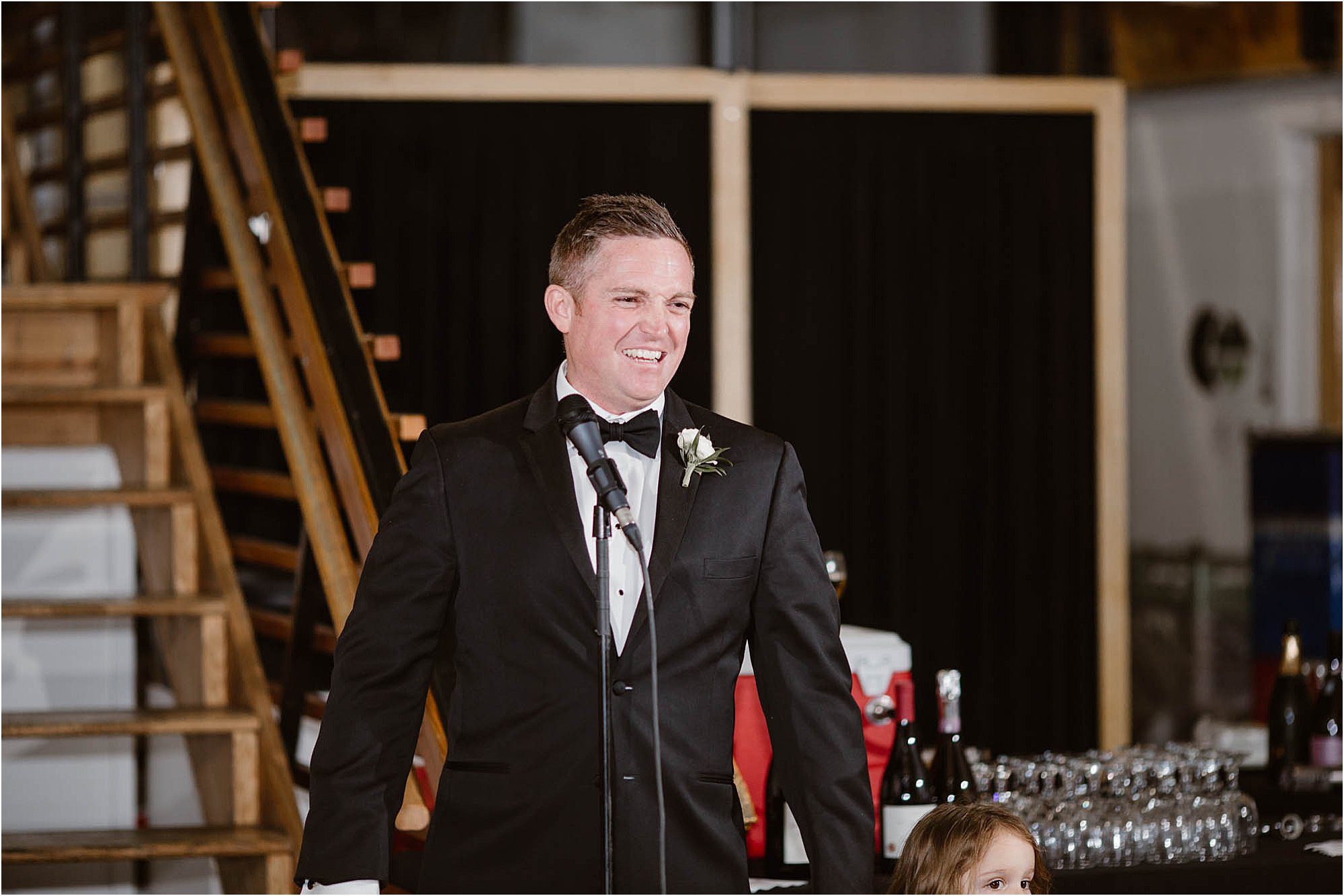 groomsman laughing while giving toasts