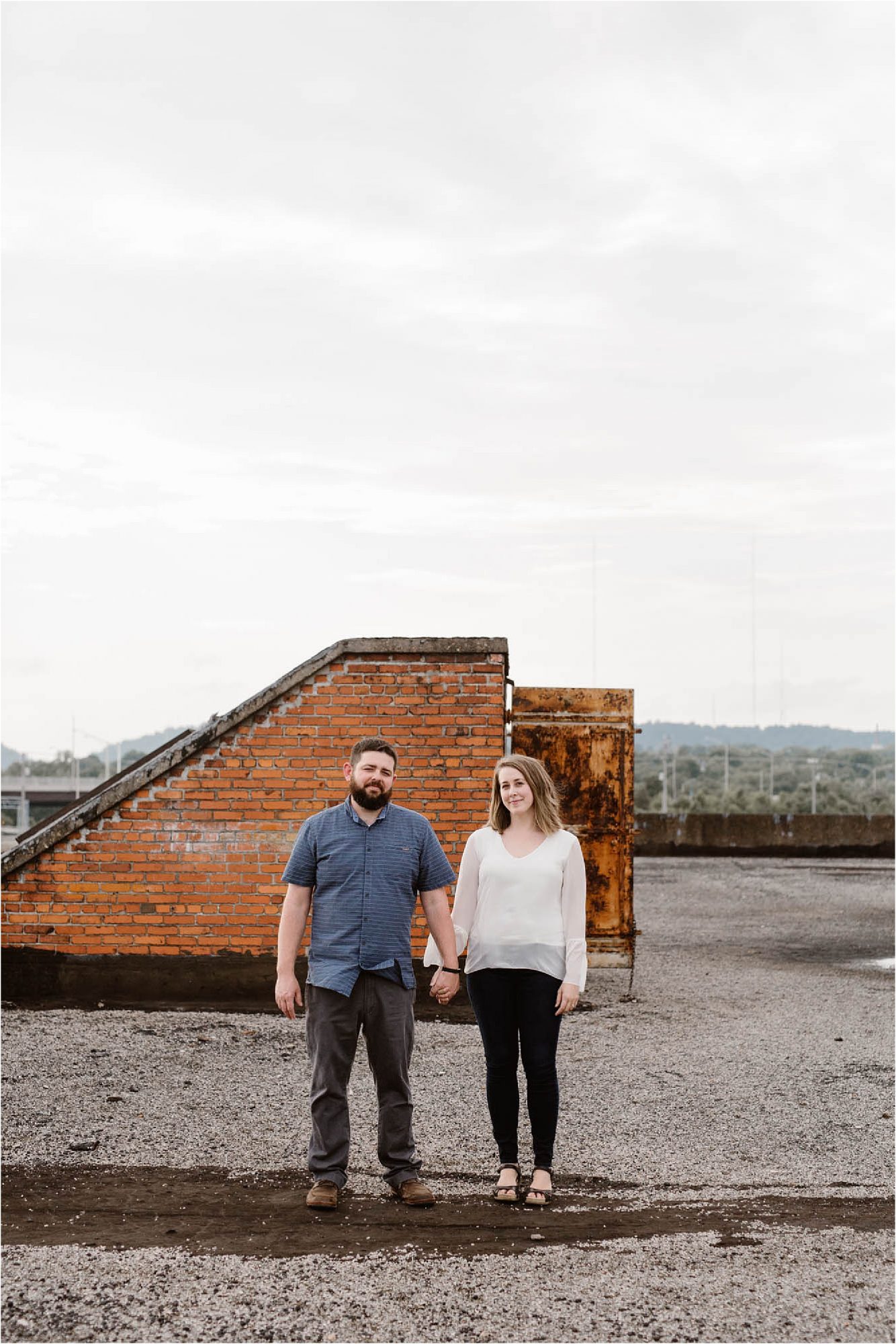 man and woman standing on warehouse roof