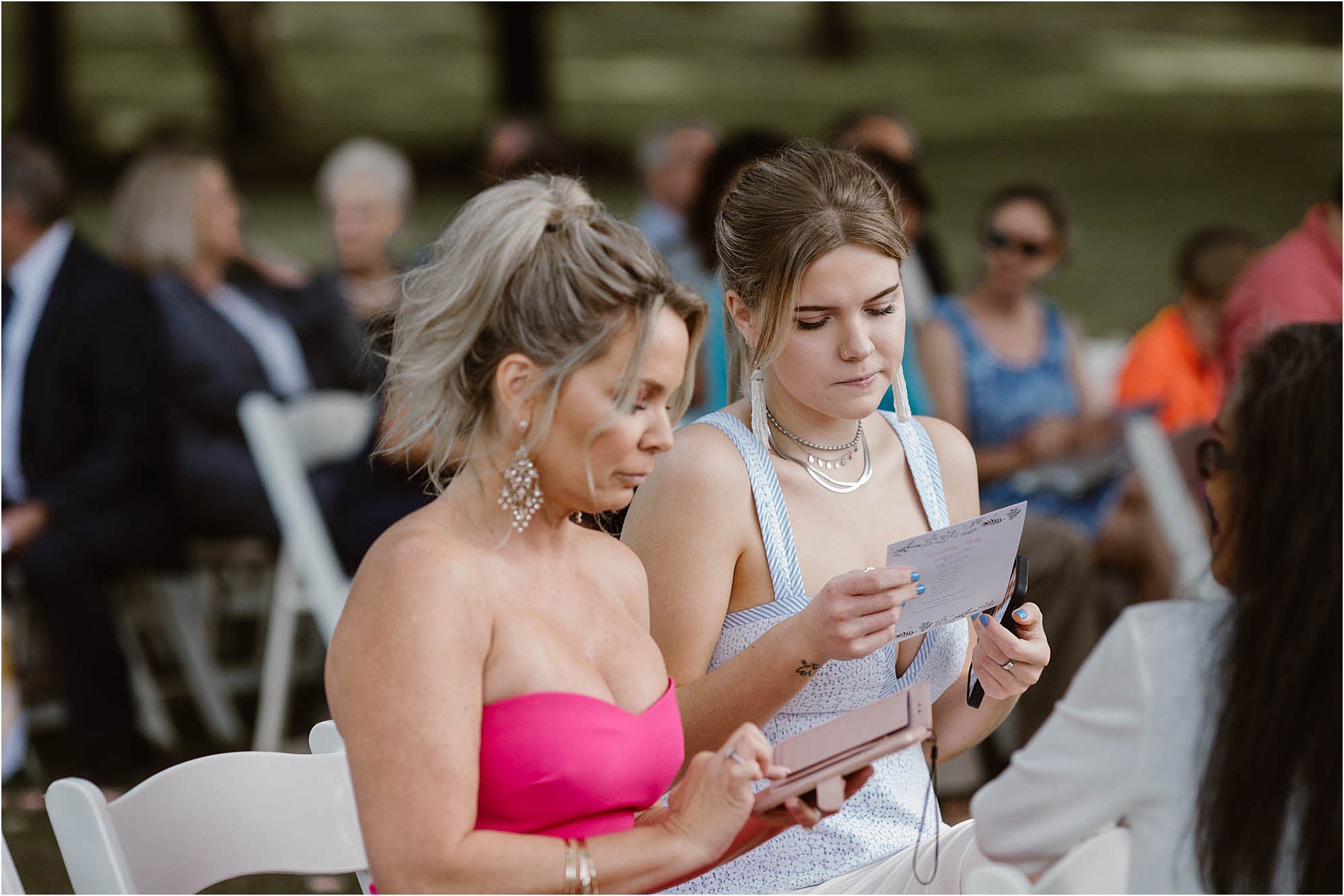 guests reading program at backyard wedding ceremony
