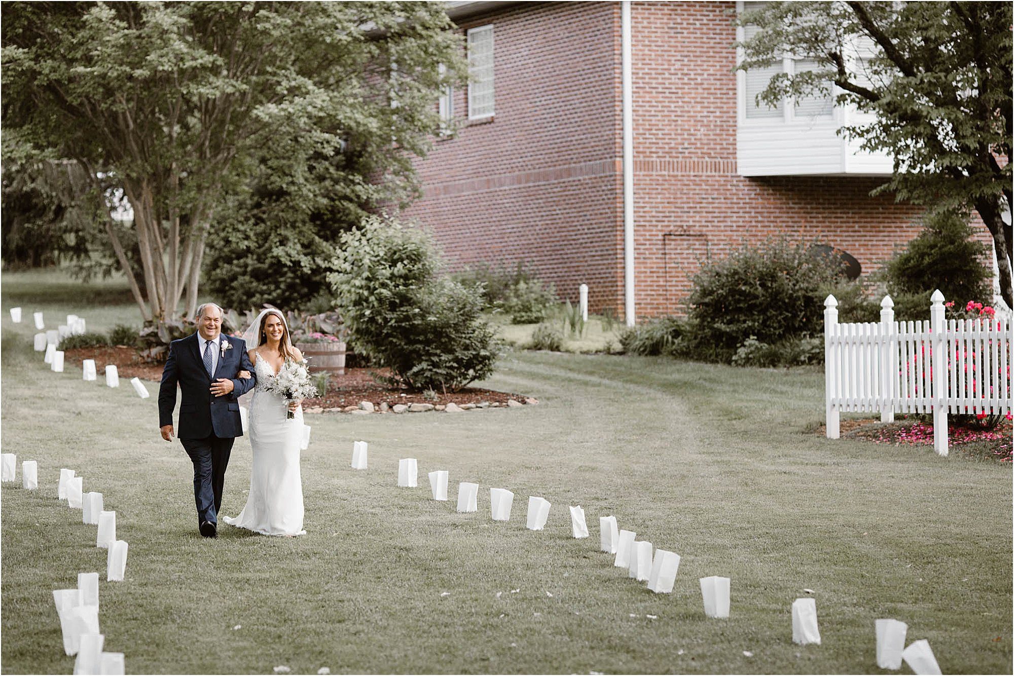 bride and father walking down aisle at backyard wedding ceremony