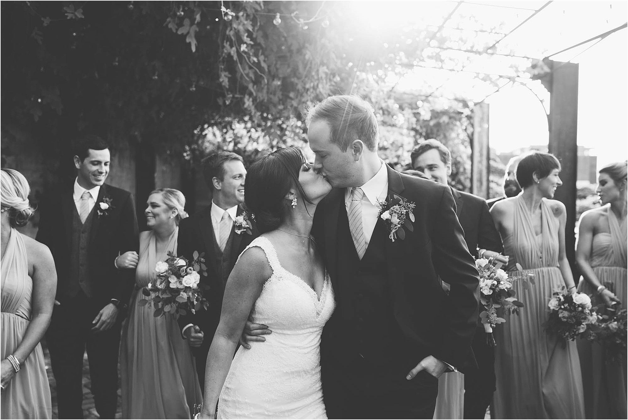 black and white photos of bride and groom kissing in front of bridal party