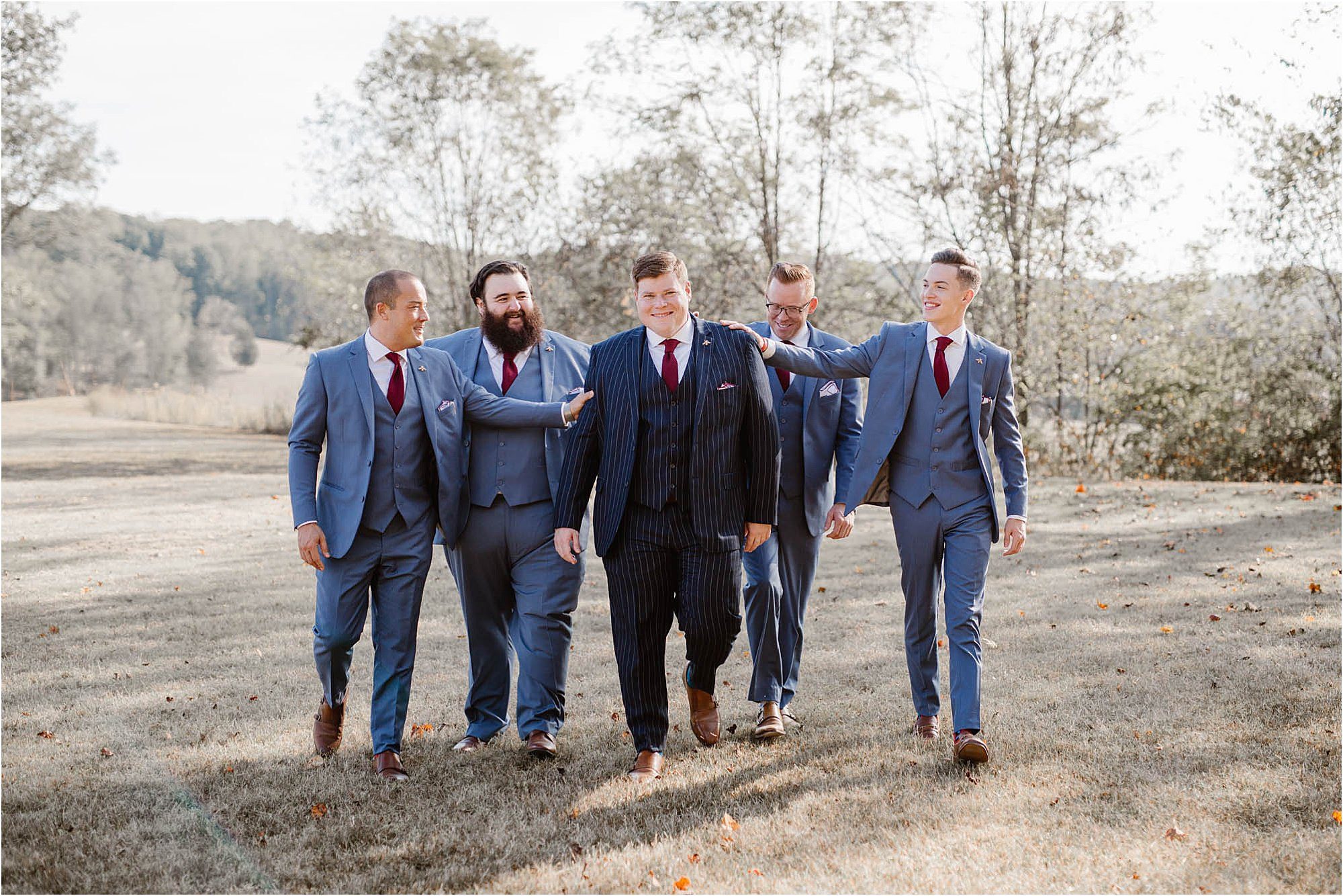 groom and groomsmen in blue suits walking