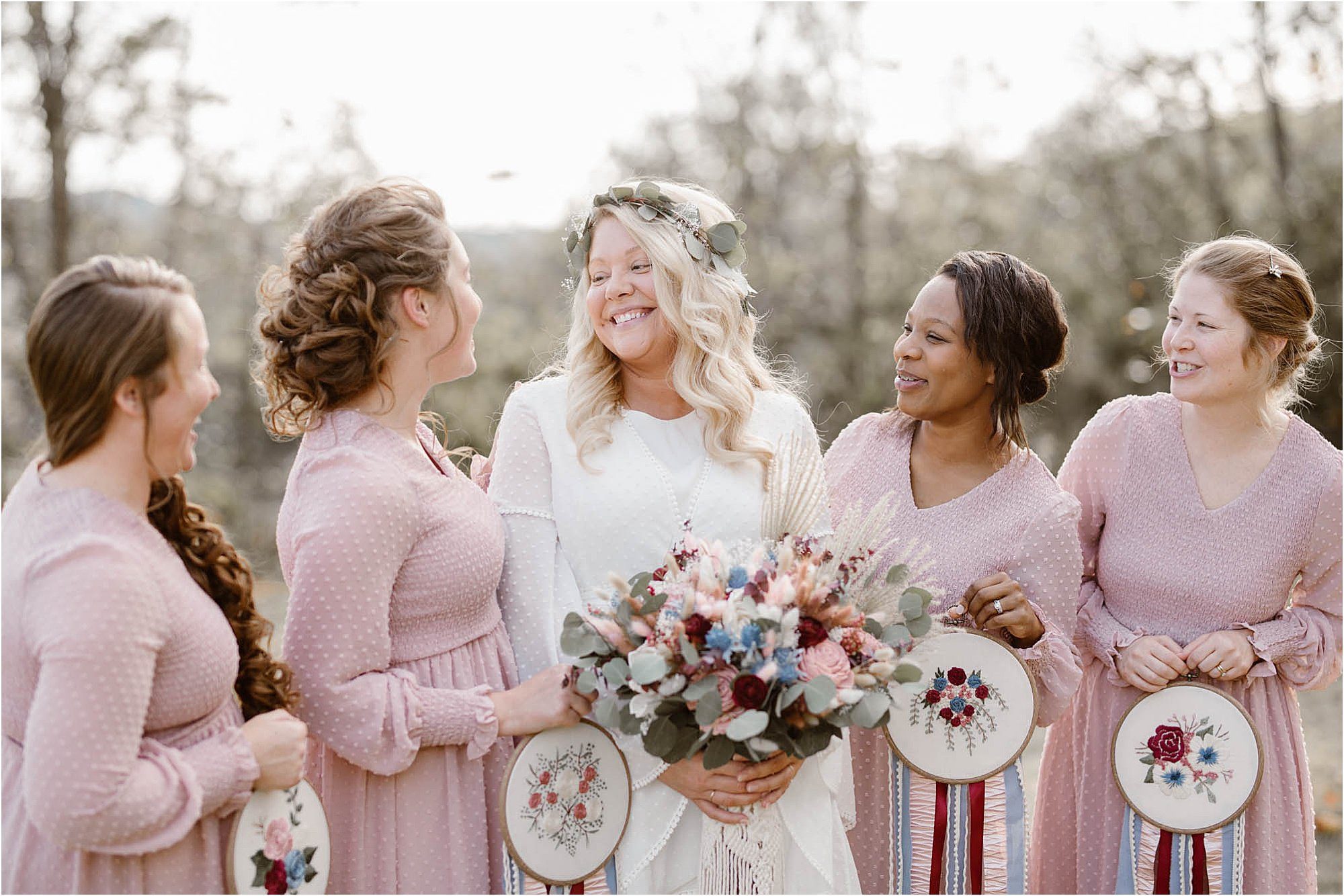 boho bride and bridesmaids in pink dresses holding needlepoint bouquets