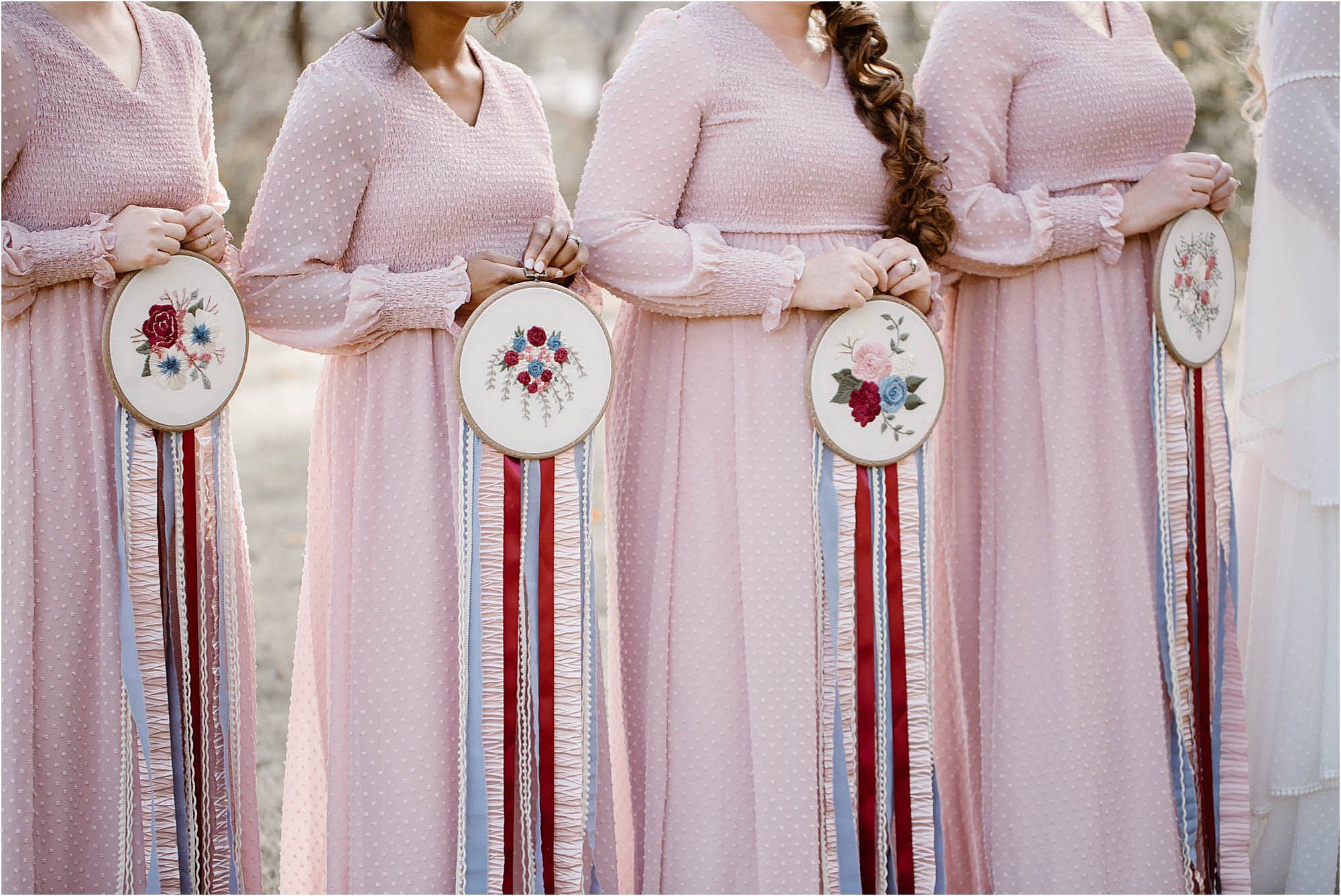 bridesmaids in pink dresses holding needlepoint bouquets