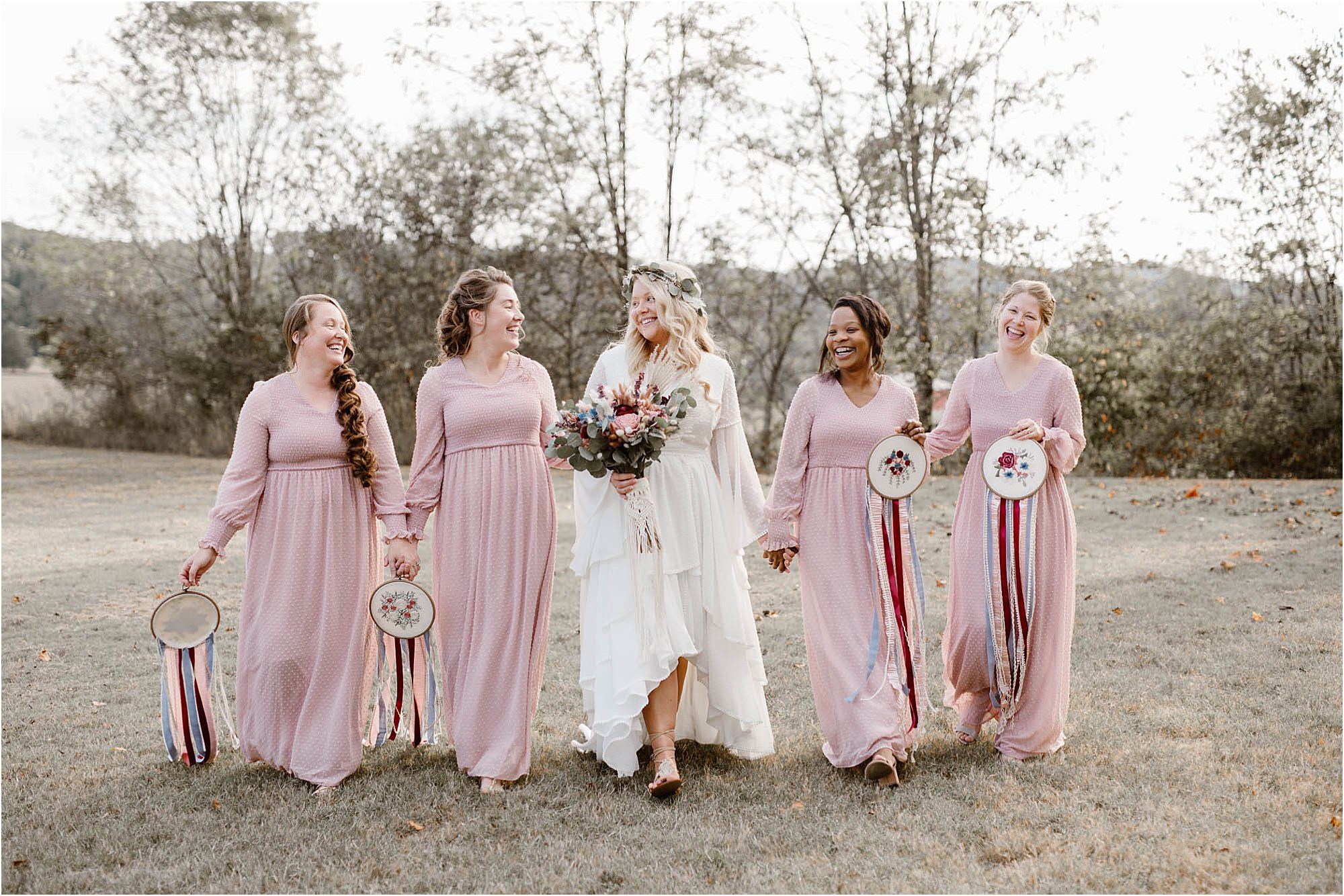 boho bride walking with bridesmaids in pink dresses