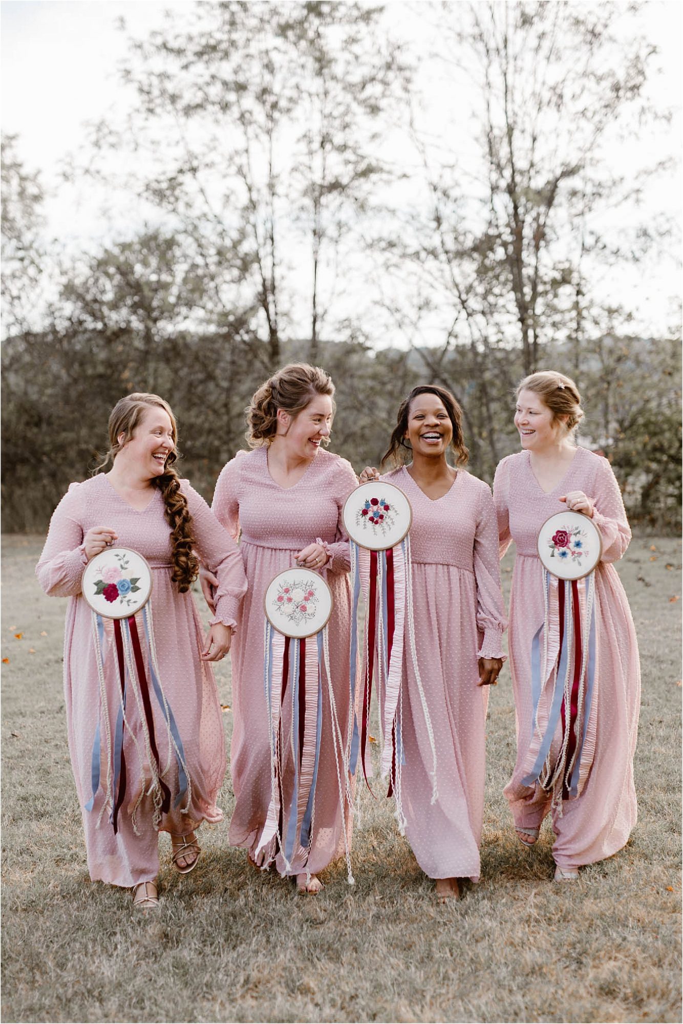 bridesmaids in light pink dresses holding needlepoint bouquets