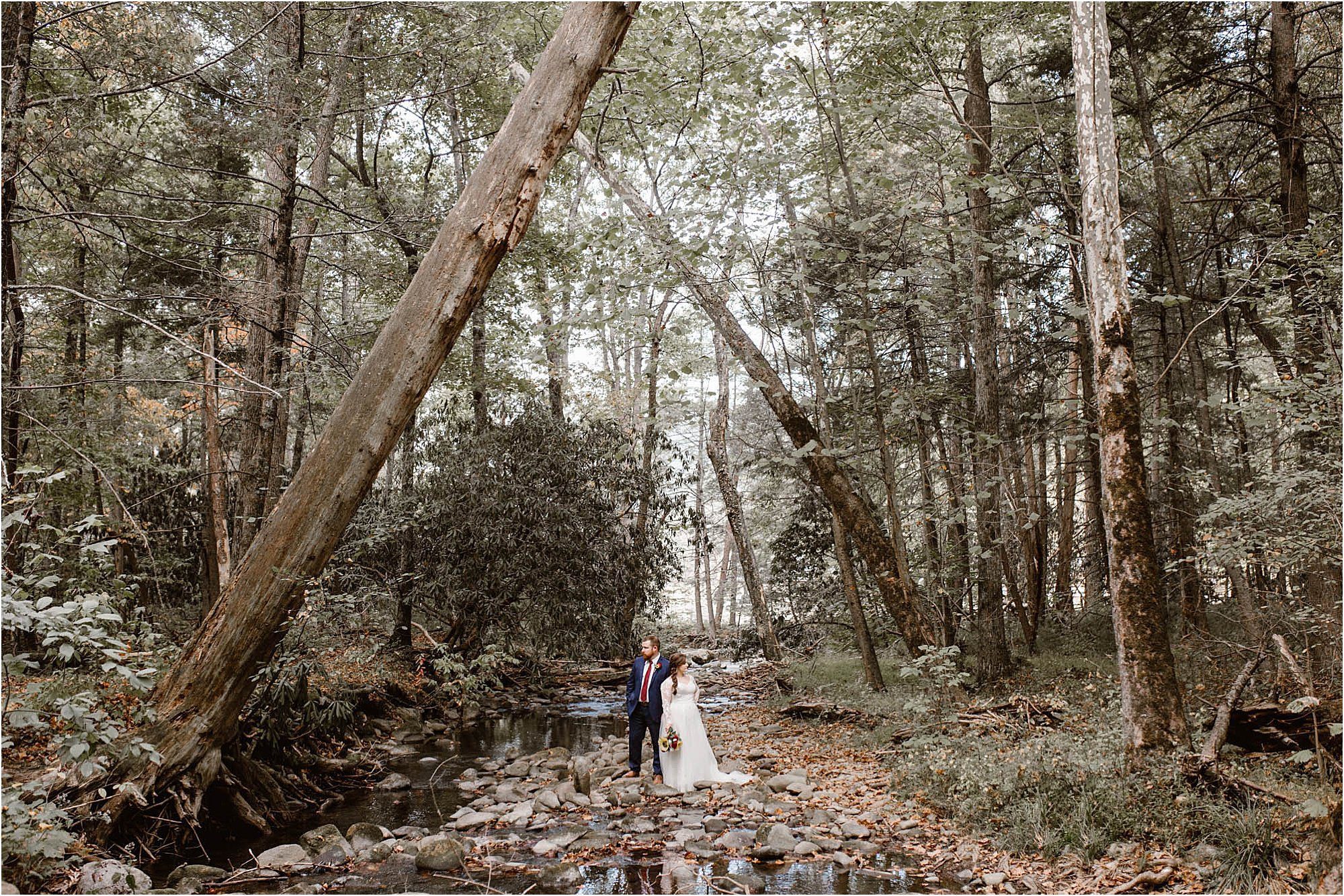 bride and groom standing on riverbed in the Smokies