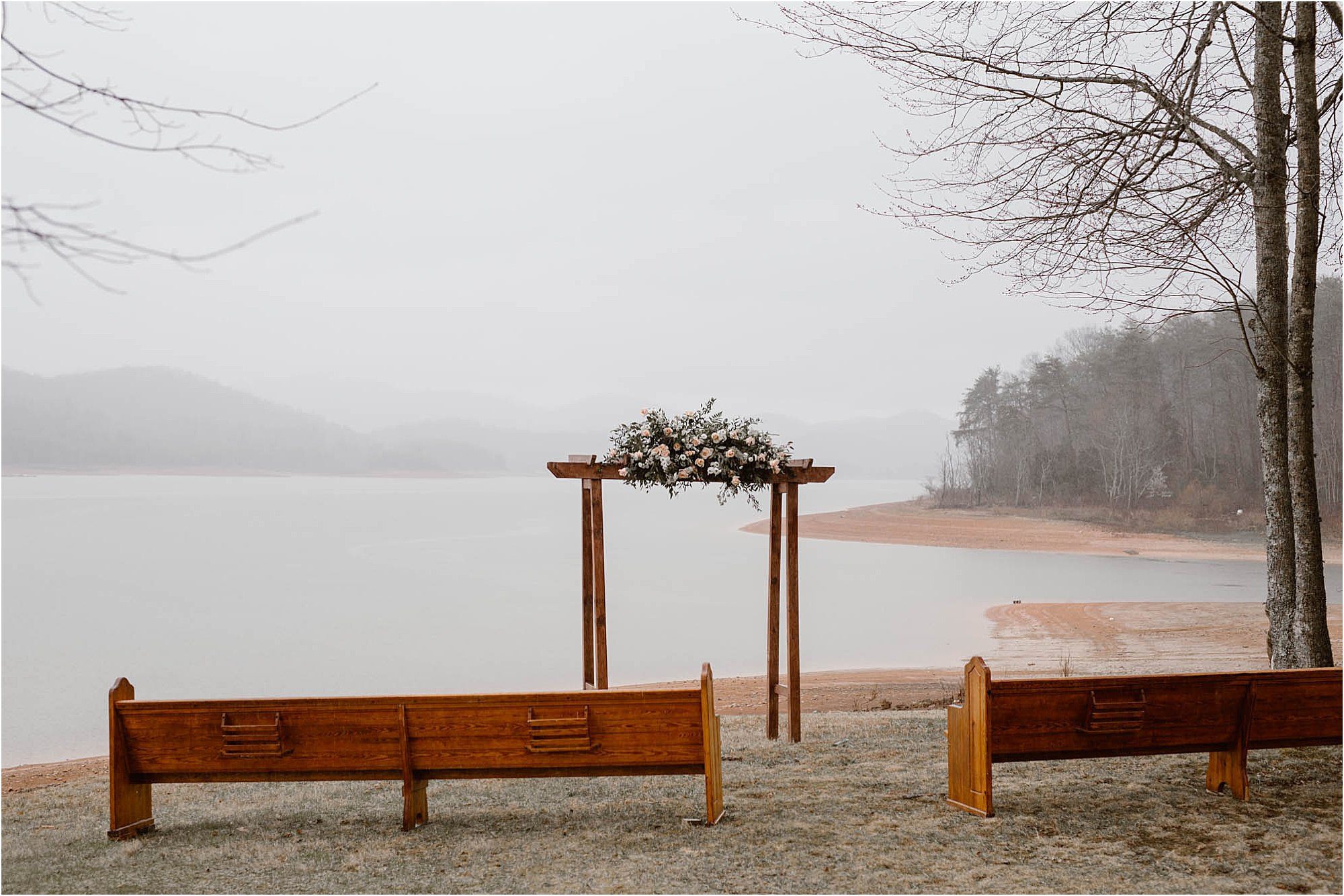 flower arbor on lake in front of pews