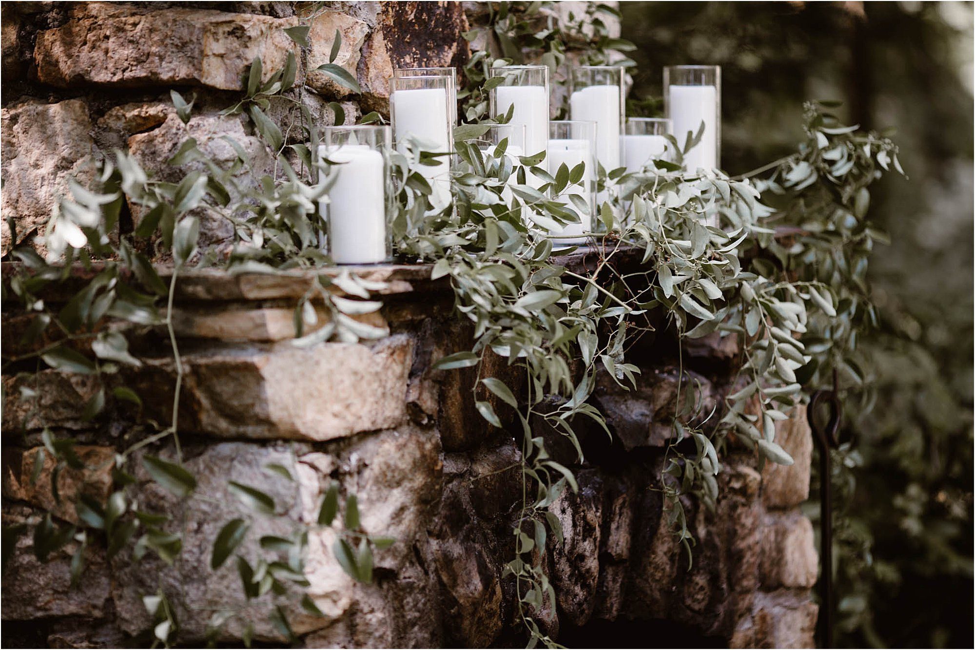 candles and greenery on outdoor fireplace