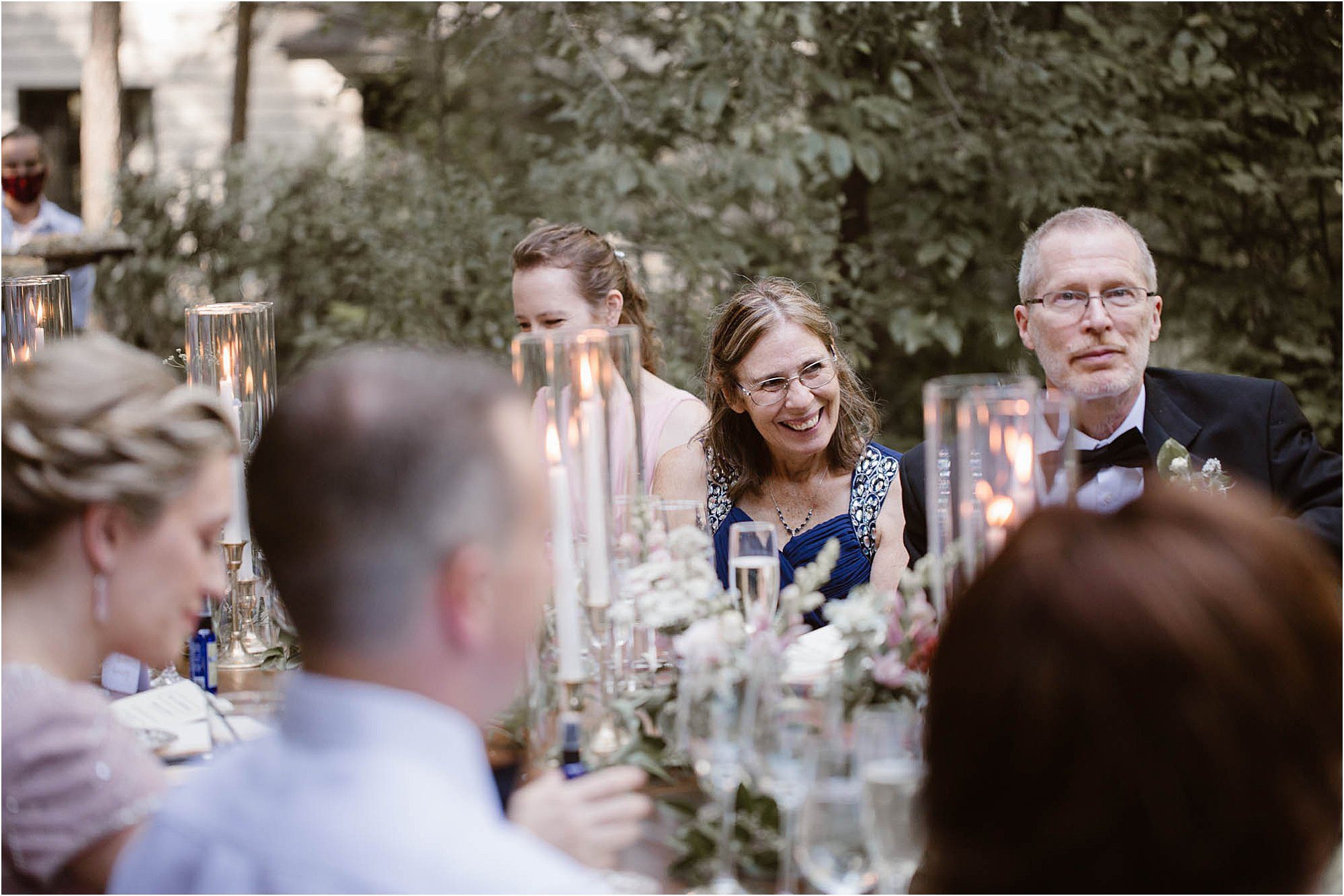 guests laughing at reception table at wedding
