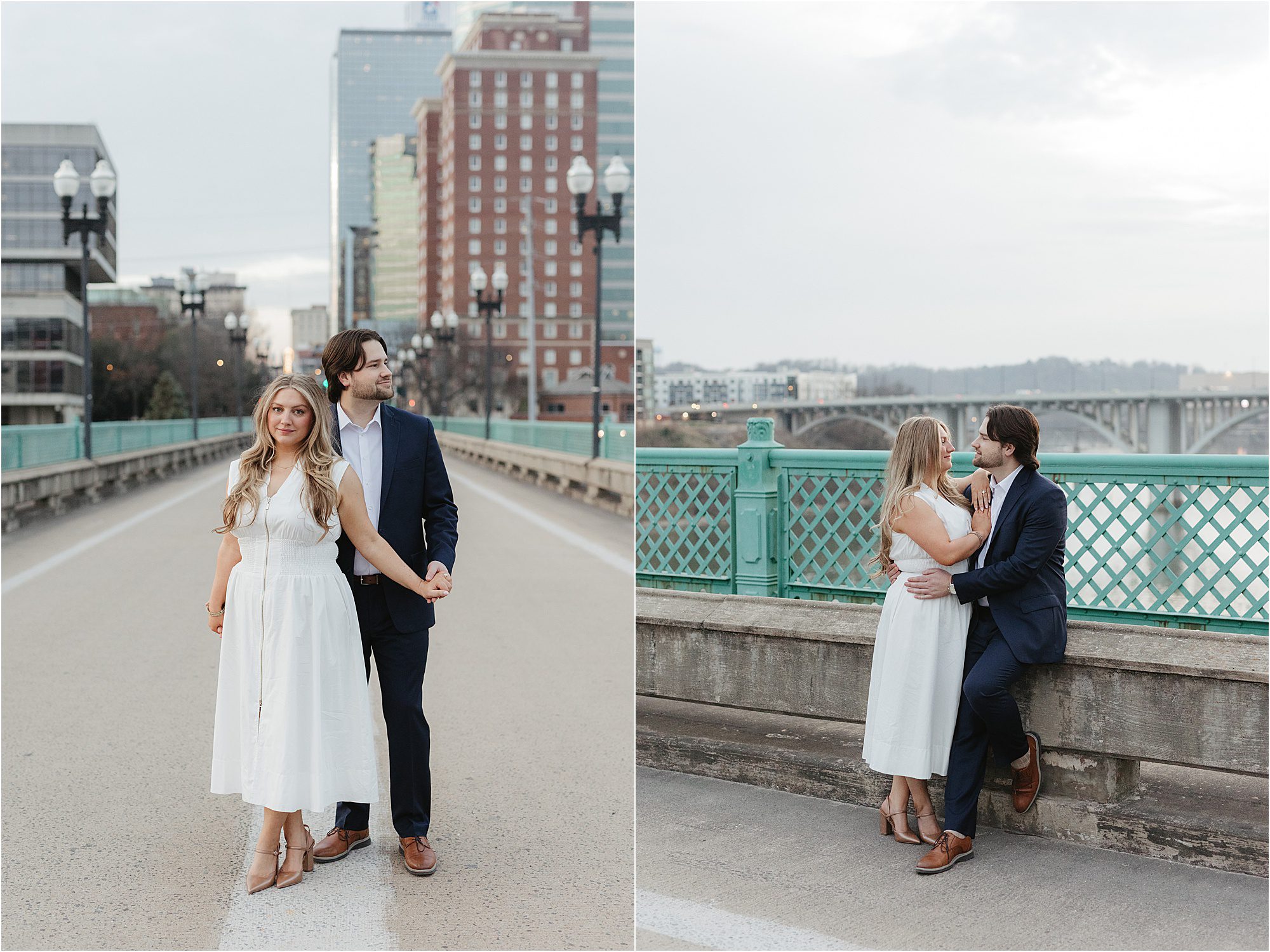 A couple dressed in formal attire poses on a city bridge—a perfect highlight for Engagement Session Locations in Knoxville—as they stand hand in hand and embrace near a green railing with urban buildings and the river behind them.