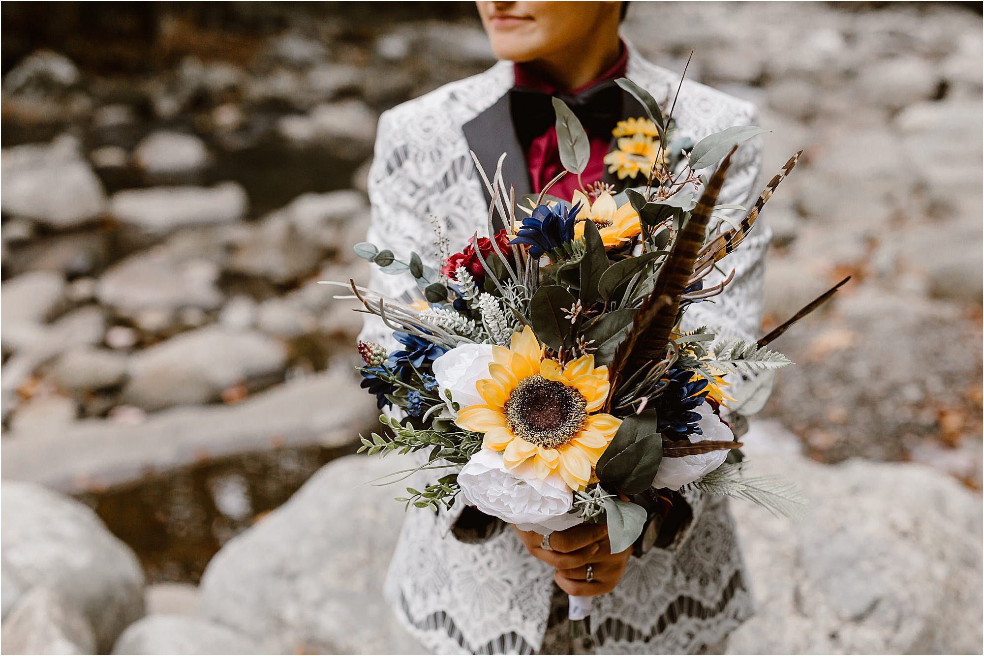 bright colorful bouquet in front of white lace suit
