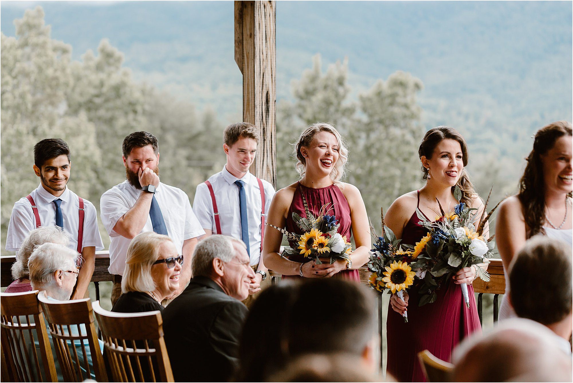 wedding party laughs during wedding ceremony at cabin