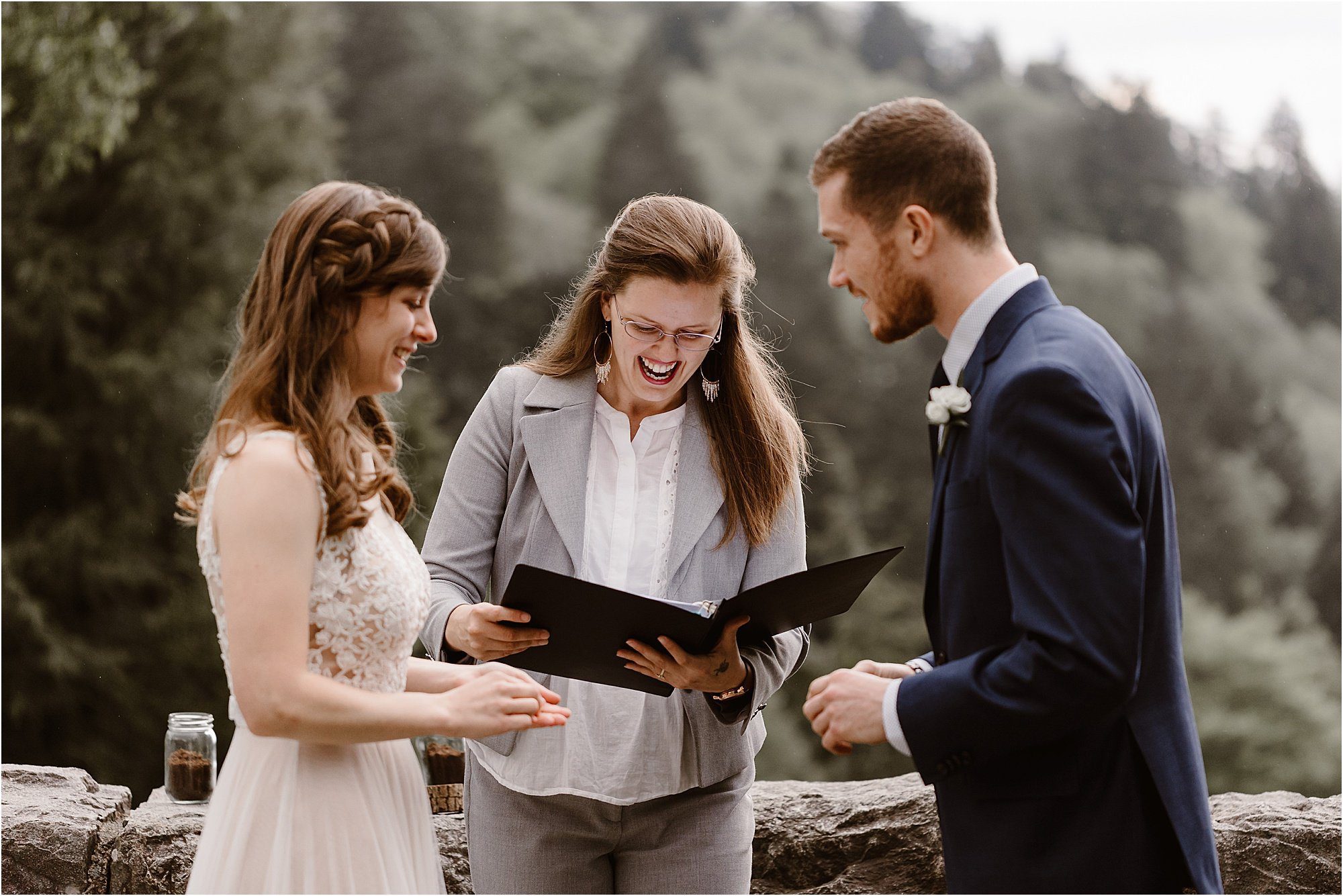 bride, groom, and officiant laugh during ring exchange at elopement
