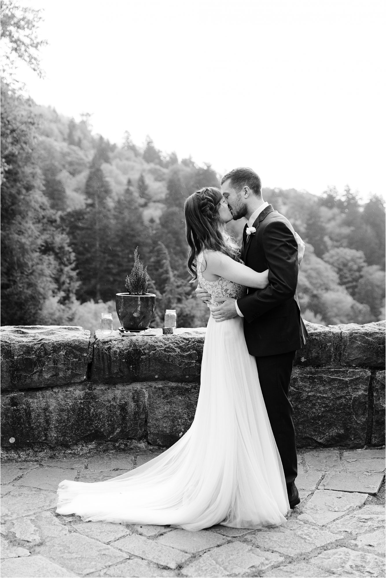 black and white wedding photo of bride and groom kissing