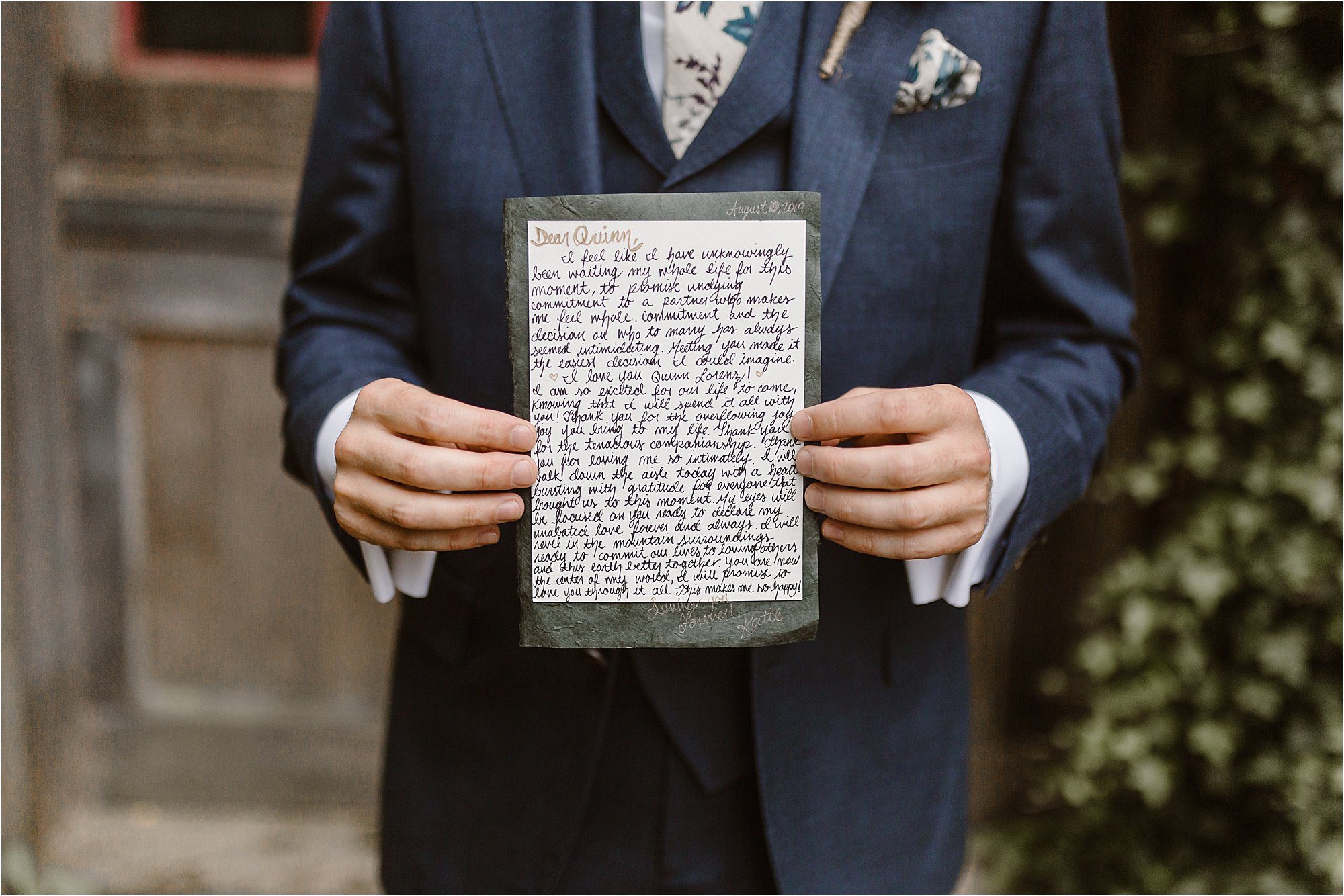 groom hold letter written by bride in front of blue jacket