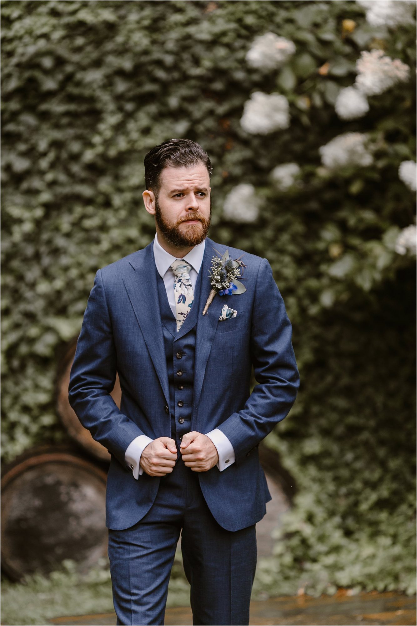 groom attire in blue jacket and flower tie with wildflower boutonniere 