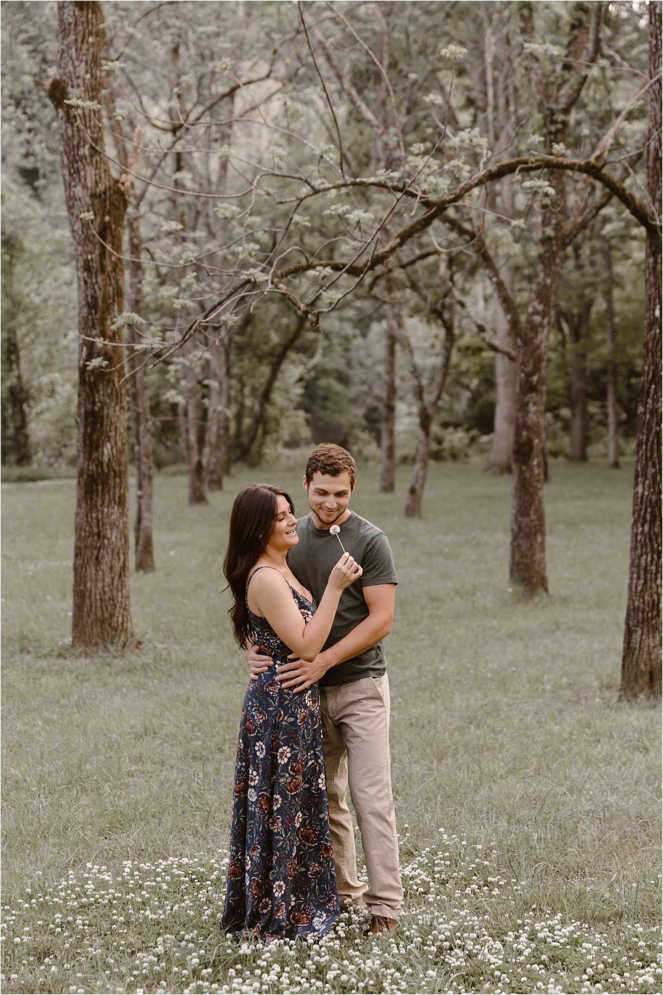 girl blowing Dandelion seeds at engagement photos